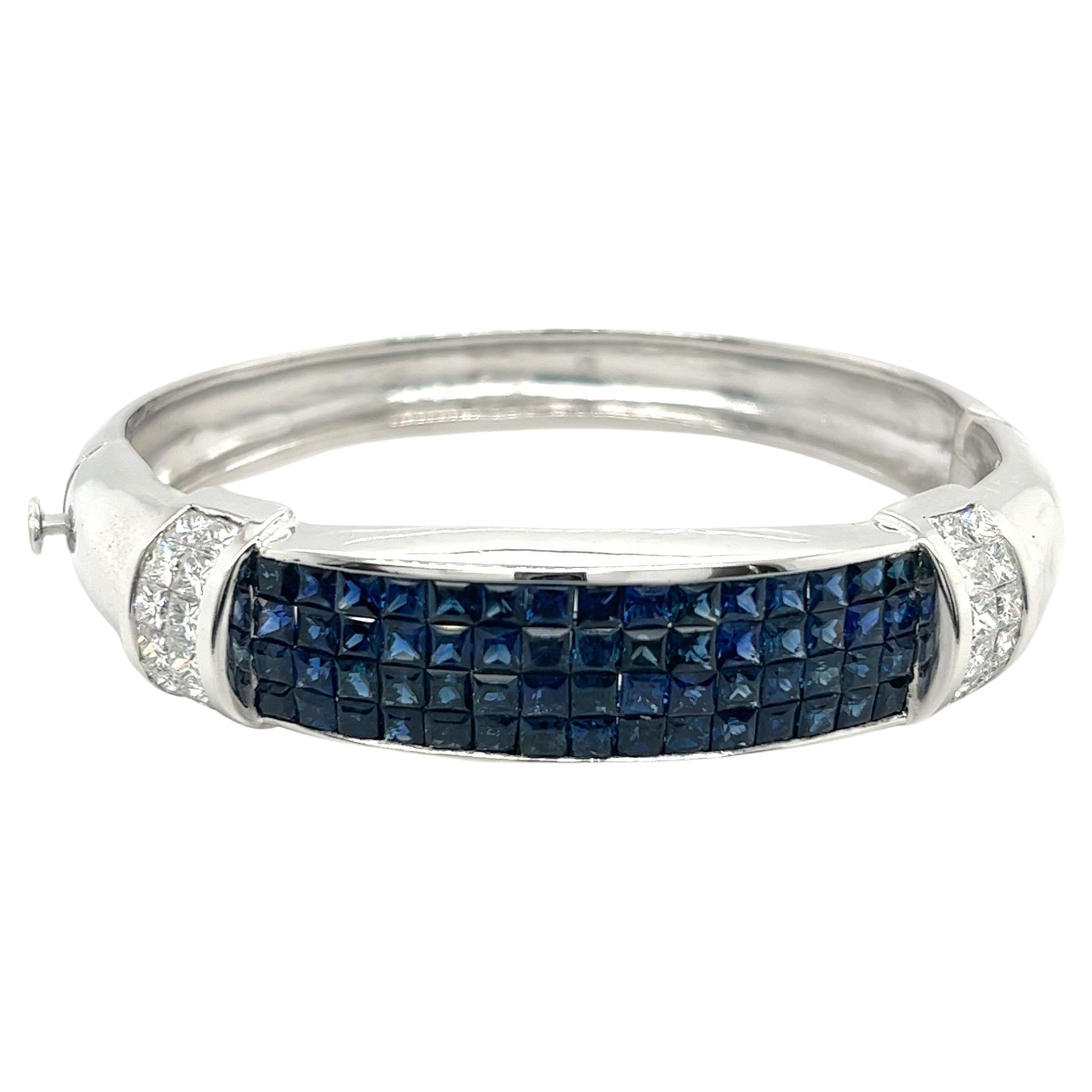 14 karat solid white gold sets 64 square cut Blue Sapphires flanked by 24 princess cut diamonds. Invisible set with expert precision and craftsmanship. Over 19 carats in gemstone excellence.

14.7 MM bracelet width offers excellent coverage on the