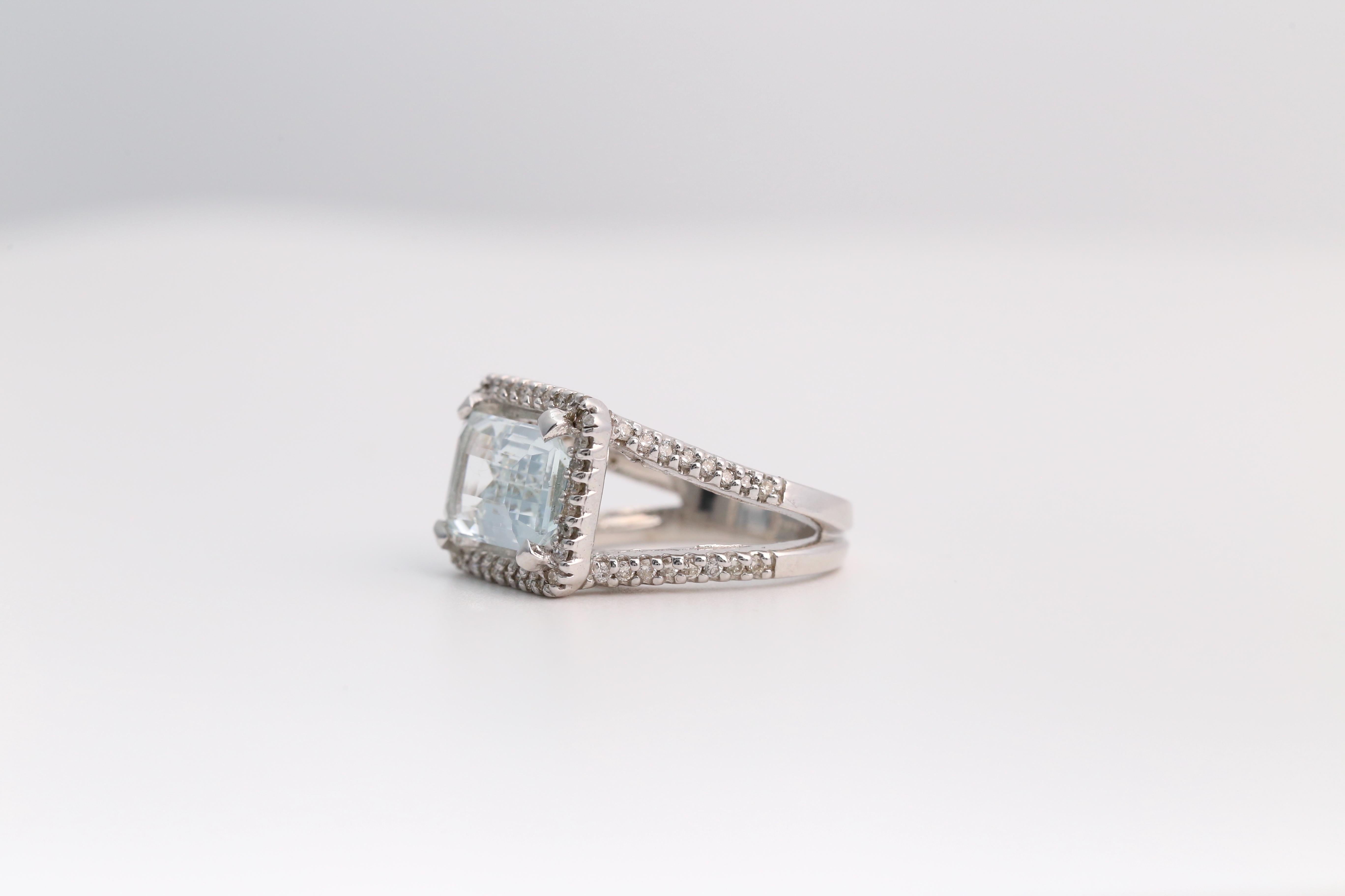 This breathtaking 14K white gold aquamarine and diamond ring radiates elegance and sophistication. The centerpiece features a 4.05-carat emerald-cut natural aquamarine, boasting a stunning icy blue hue with exceptional clarity. Surrounding the