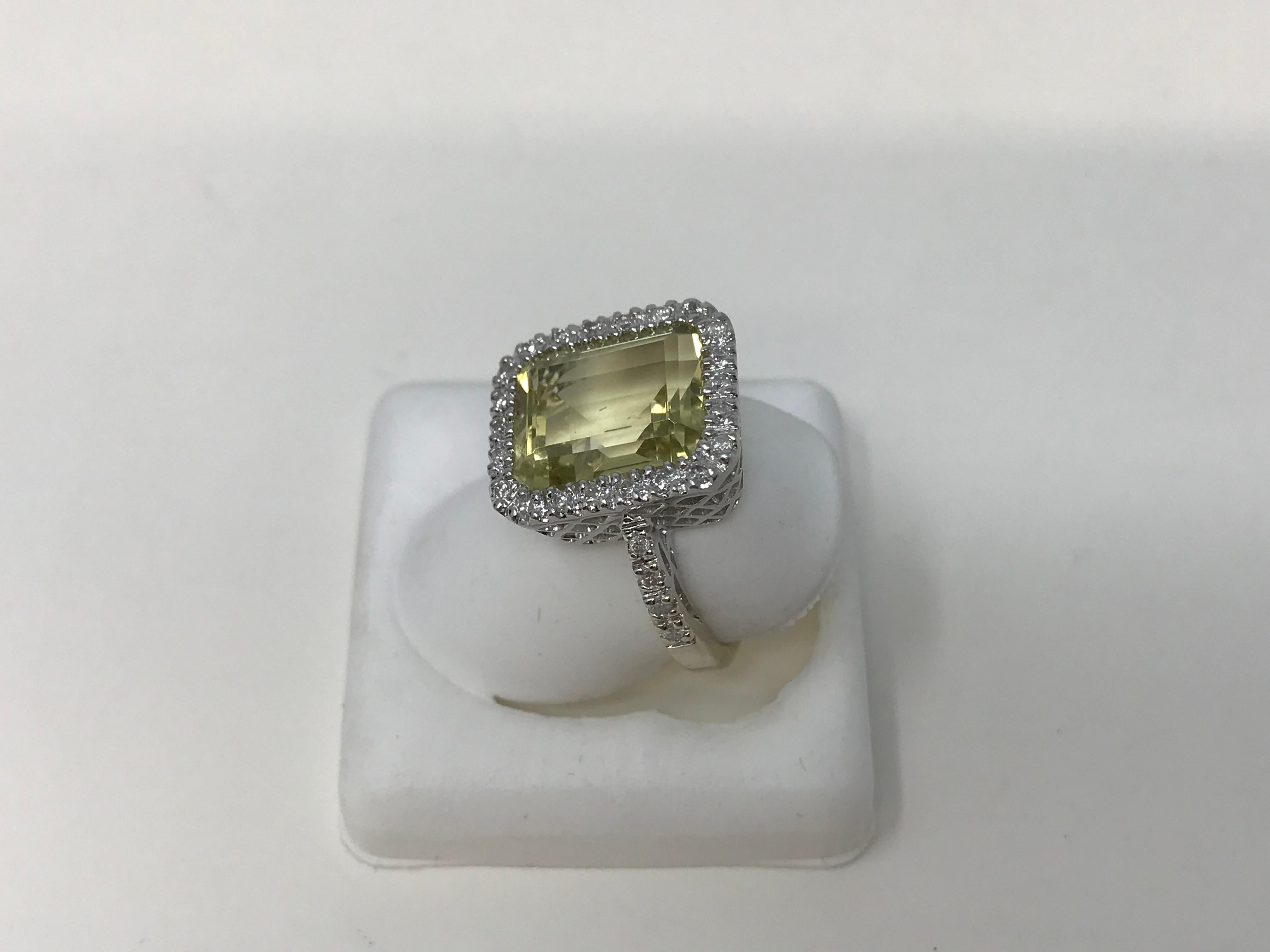 14k white gold ladies ring set with lemon quartz, emerald cut, 12 x 10 mm and 30 diamonds of .001 ct each; purity I, clarity h-I and stamped 14k. Maker unknown, made in Canada circa 2000. With a rhodium finish and in good condition. 