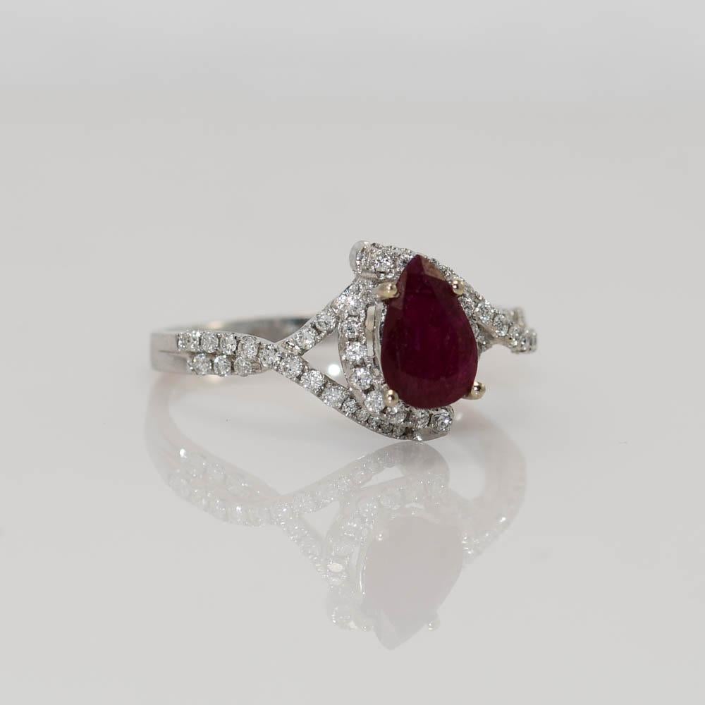 14 karat white gold ruby and diamond ring.
The main center stone is a 1.00ct, 8 x 5 millimeter Pear shaped ruby mounted in a 4 prong setting.
There are 50 small round brilliant diamonds with a total of 0.50 carat diamond weight with SI1 clarity and