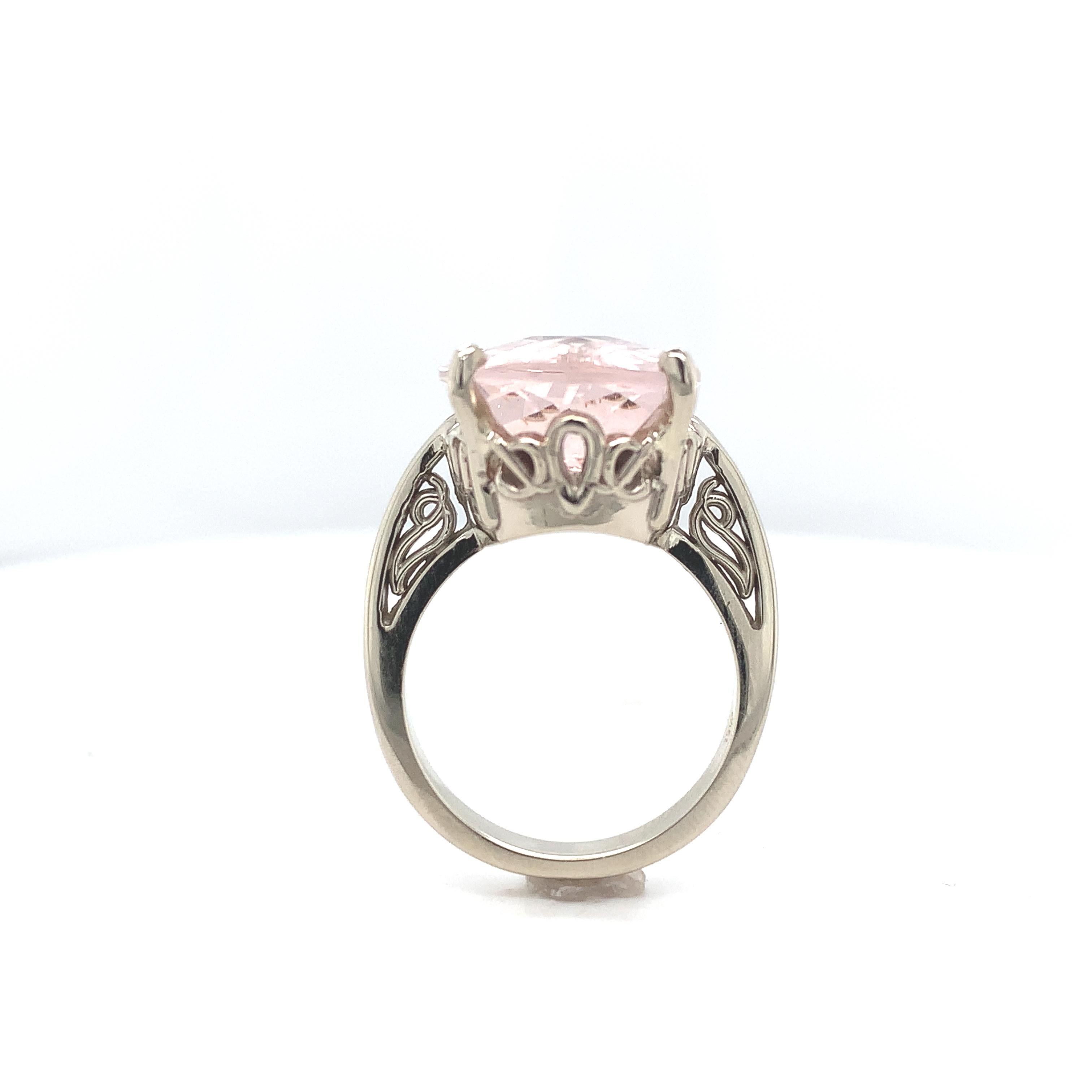 14K white gold ring featuring a large cushion cut morganite weighing 10.85 carats. The genuine earth mined morganite has light pink/peach color and measures about 18mm x 13mm. The morganite has a checkerboard top. Morganite is the peach or pink