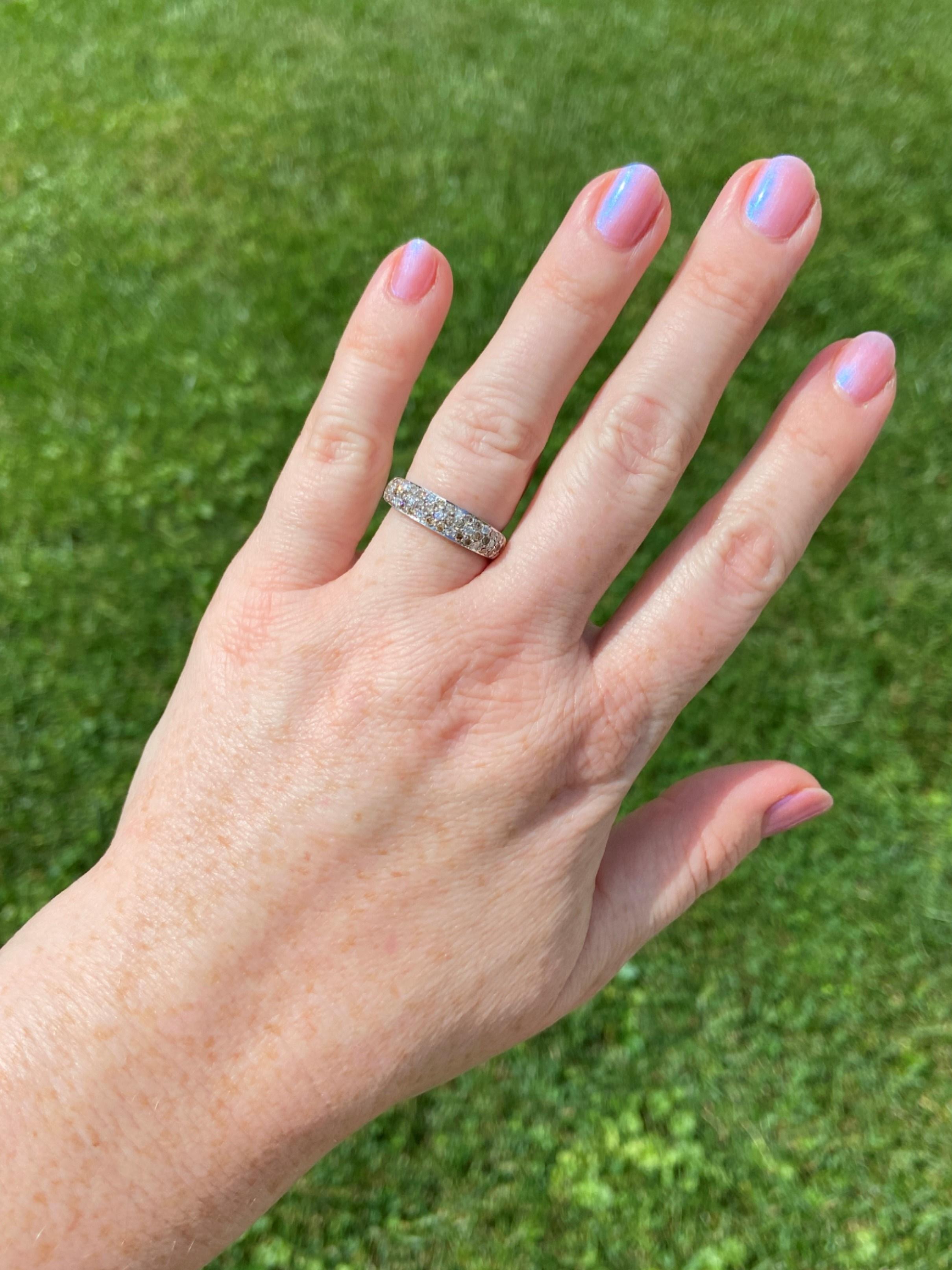 In this 14 karat white gold and diamond Levian band, champagne and white diamonds are pave' set into a daisy pattern. The white gold and white diamonds, which are G - H color grade, are the backdrop for six-petaled champagne diamond flowers in a