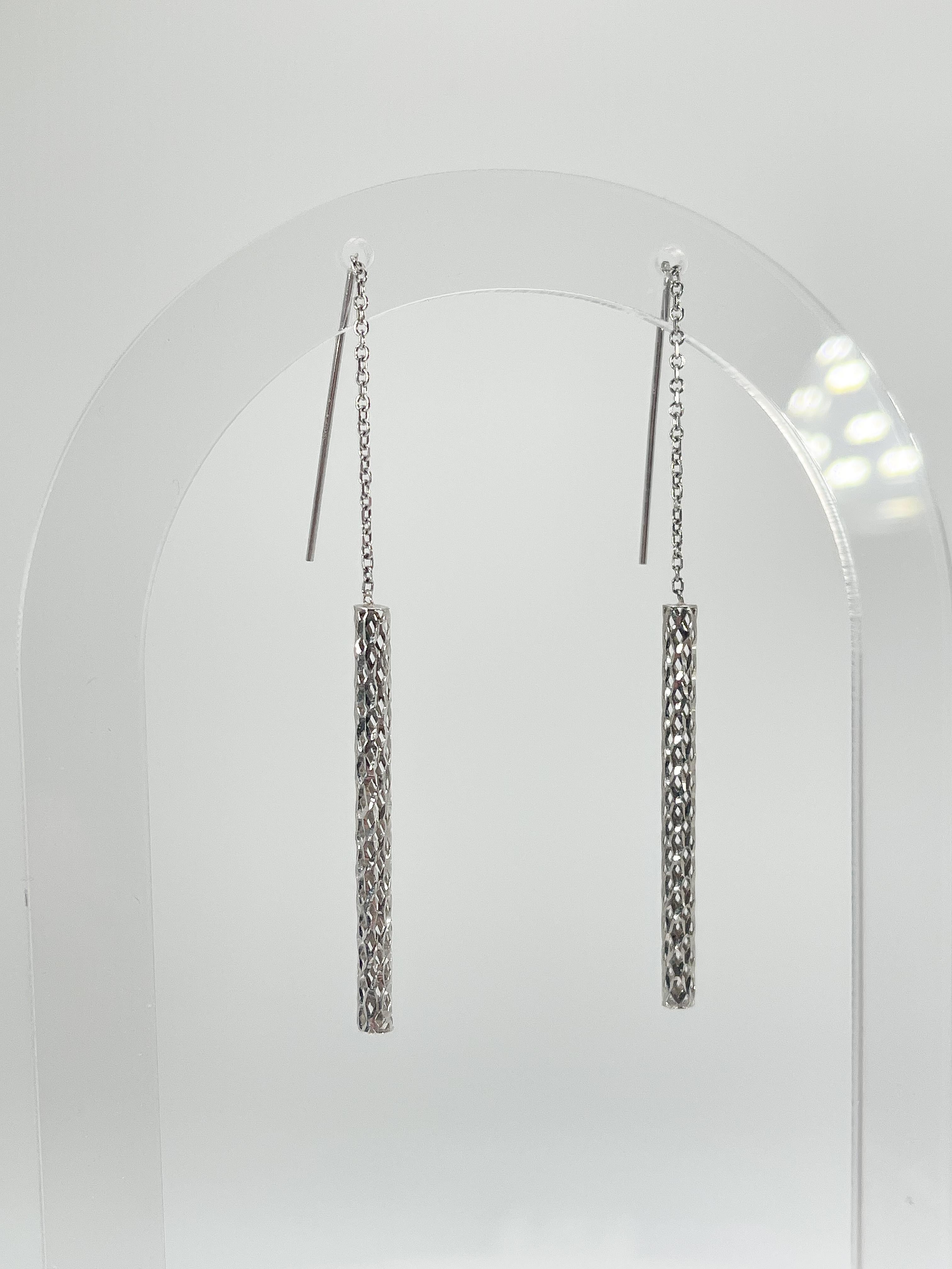 14k white gold fancy tube threader earrings. The length of the earrings can be slightly adjusted. Tubes measure 35.3 x 2.7 mm, and the total weight is 1.44 grams.