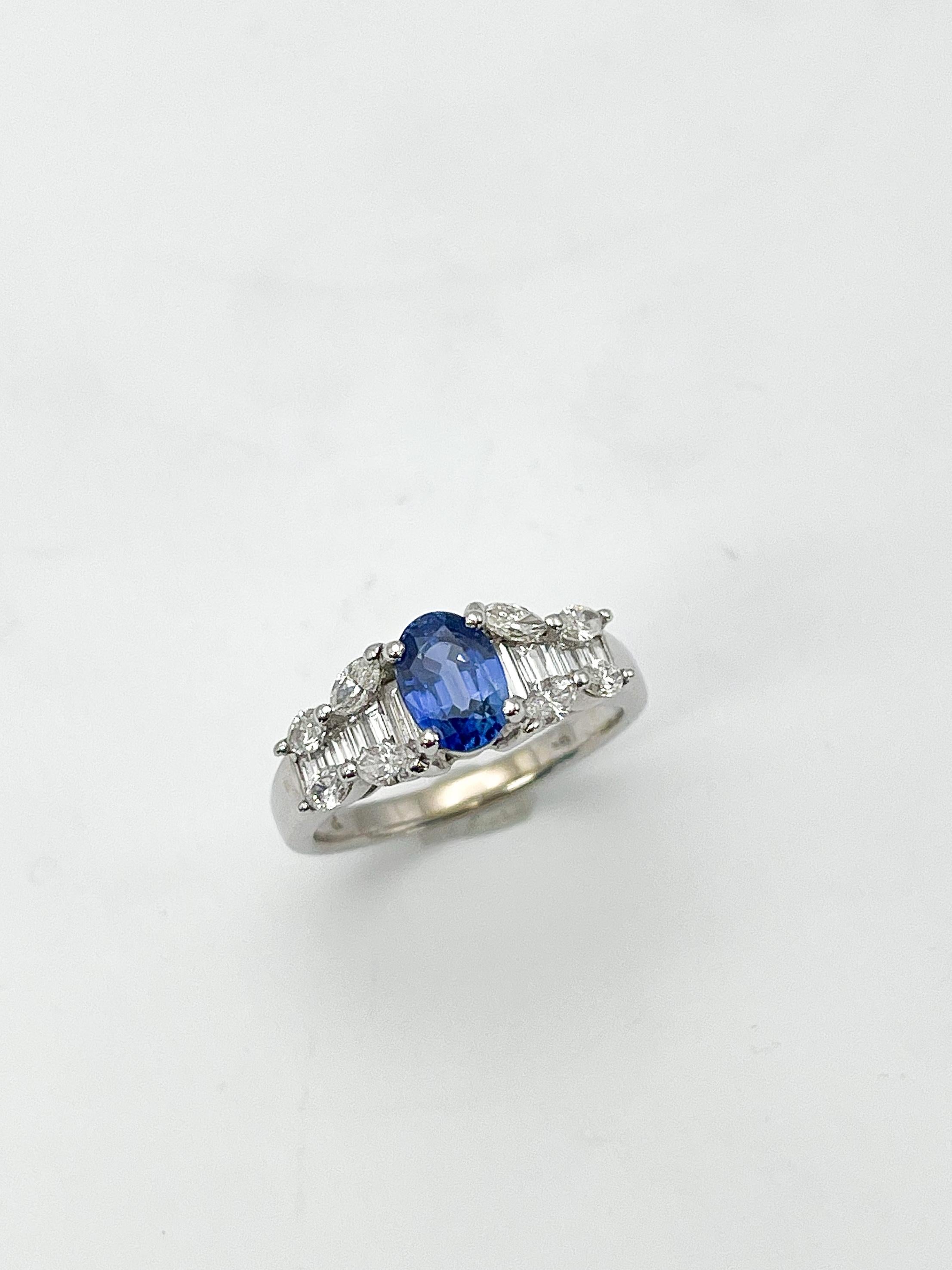 Ring aus 14k Weißgold mit Diamanten und blauem ovalen Saphir. Dieser Ring hat 8 Diamanten im Marquiseschliff und 14 Baguette-Diamanten zusammen mit dem Saphir. Der Saphir misst 4,7x6,8 mm, der Ring hat die Größe 5 3/4, das Band ist 2 mm breit und