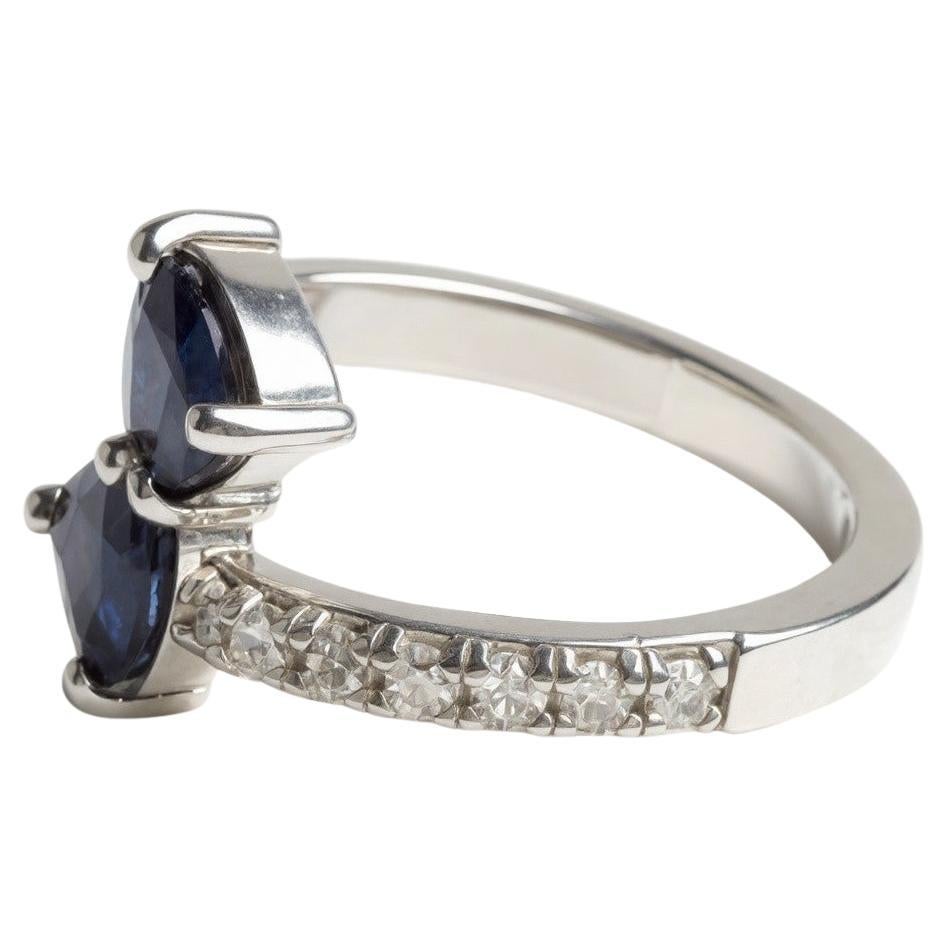 This exquisite 14K white gold cross ring features two matched pear-shaped natural sapphires with a combined weight of 1.90 carats, beautifully accented by 0.50 carats of fine diamonds. Sized at 6.25, this elegant design offers the perfect balance of