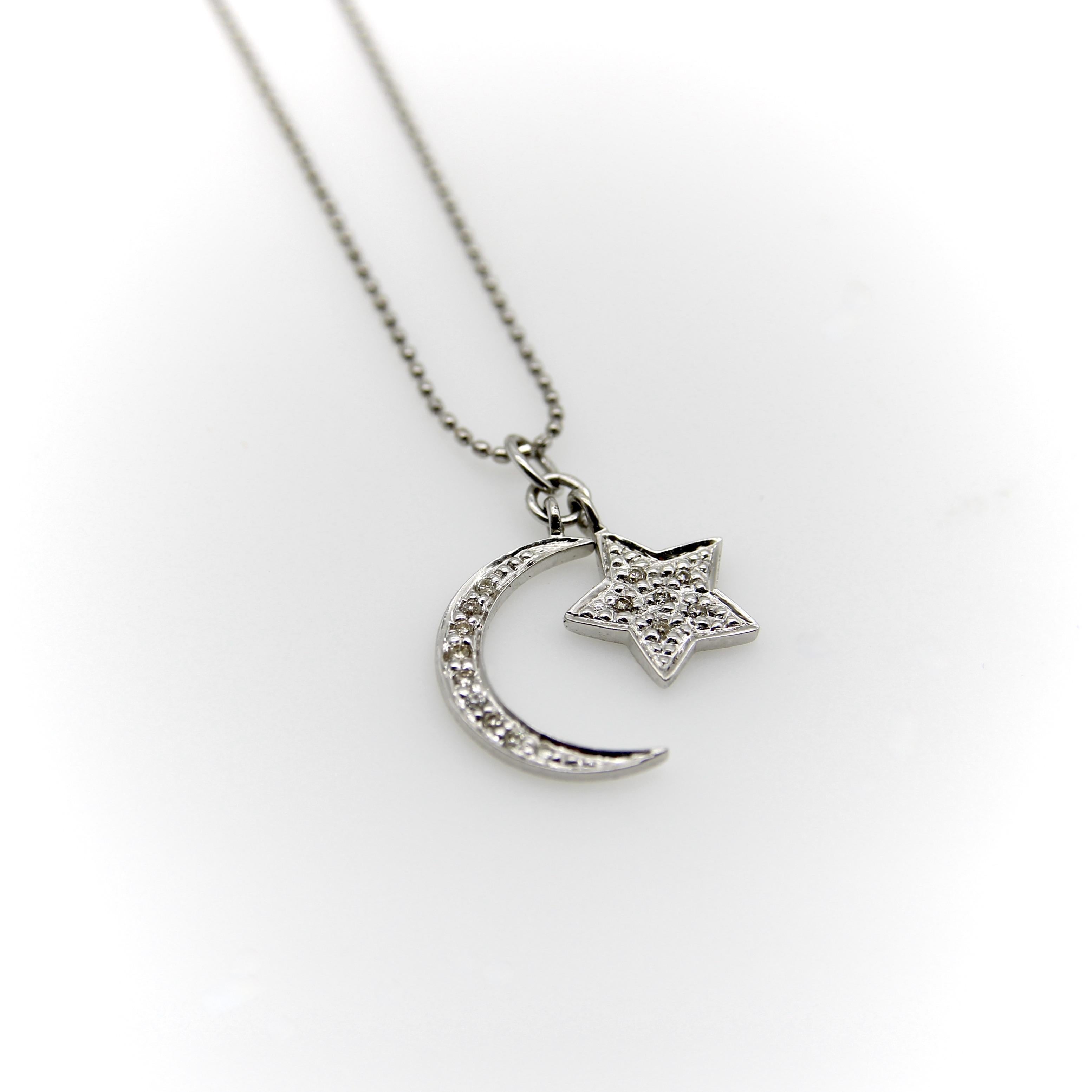 Questa collana in oro bianco 14k presenta una stella e una mezzaluna che pendono da una delicata catena a palline. La luna e la stella sono impreziosite da diamanti incastonati; una texture a punti sulla superficie della stella in oro bianco esalta