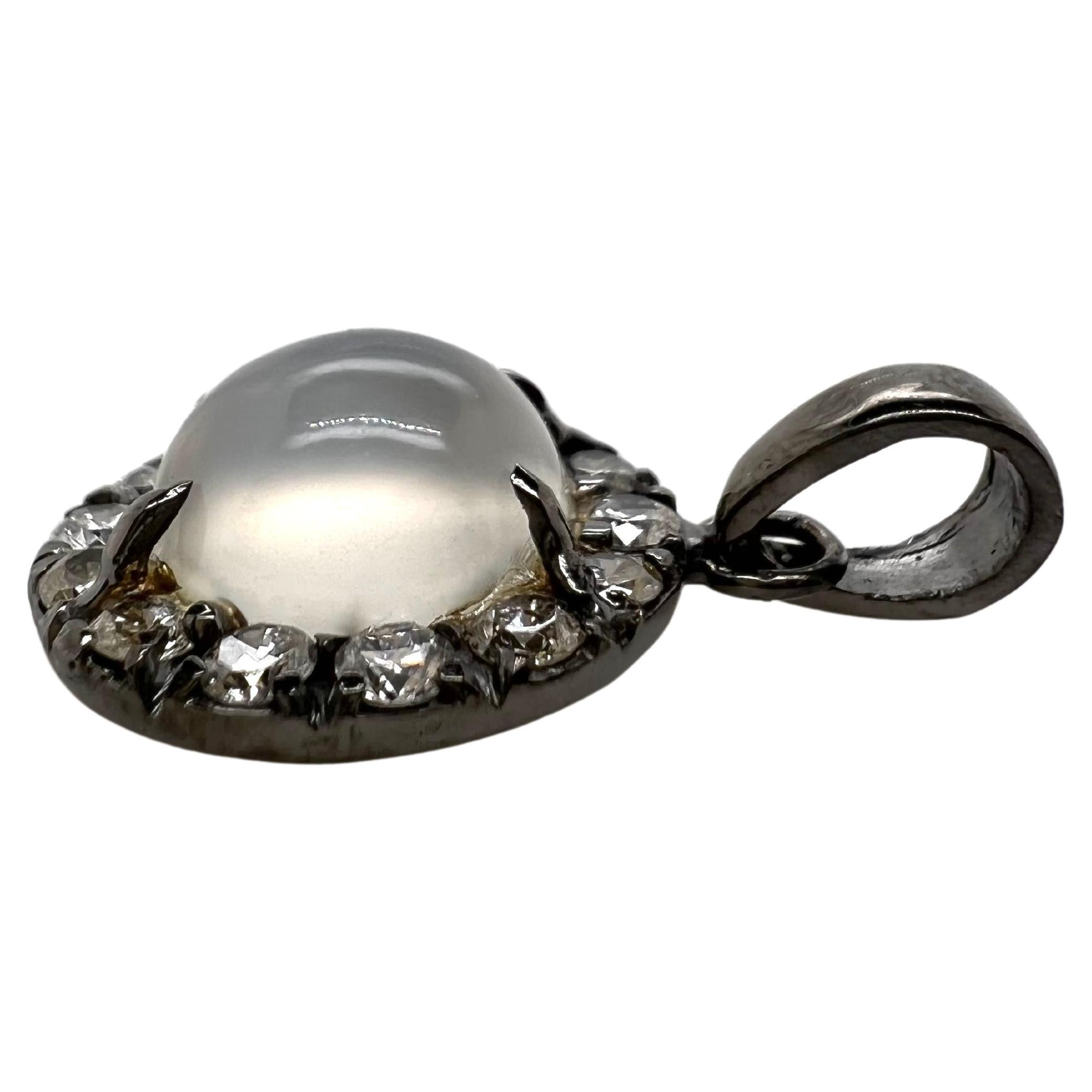 Ce pendentif en or blanc 14 carats en forme de pierre de lune est serti de diamants ronds brillants et recouvert de rhodium noir pour lui donner un aspect contrasté unique.  La pierre de lune est le point focal ; les diamants blancs forment un beau