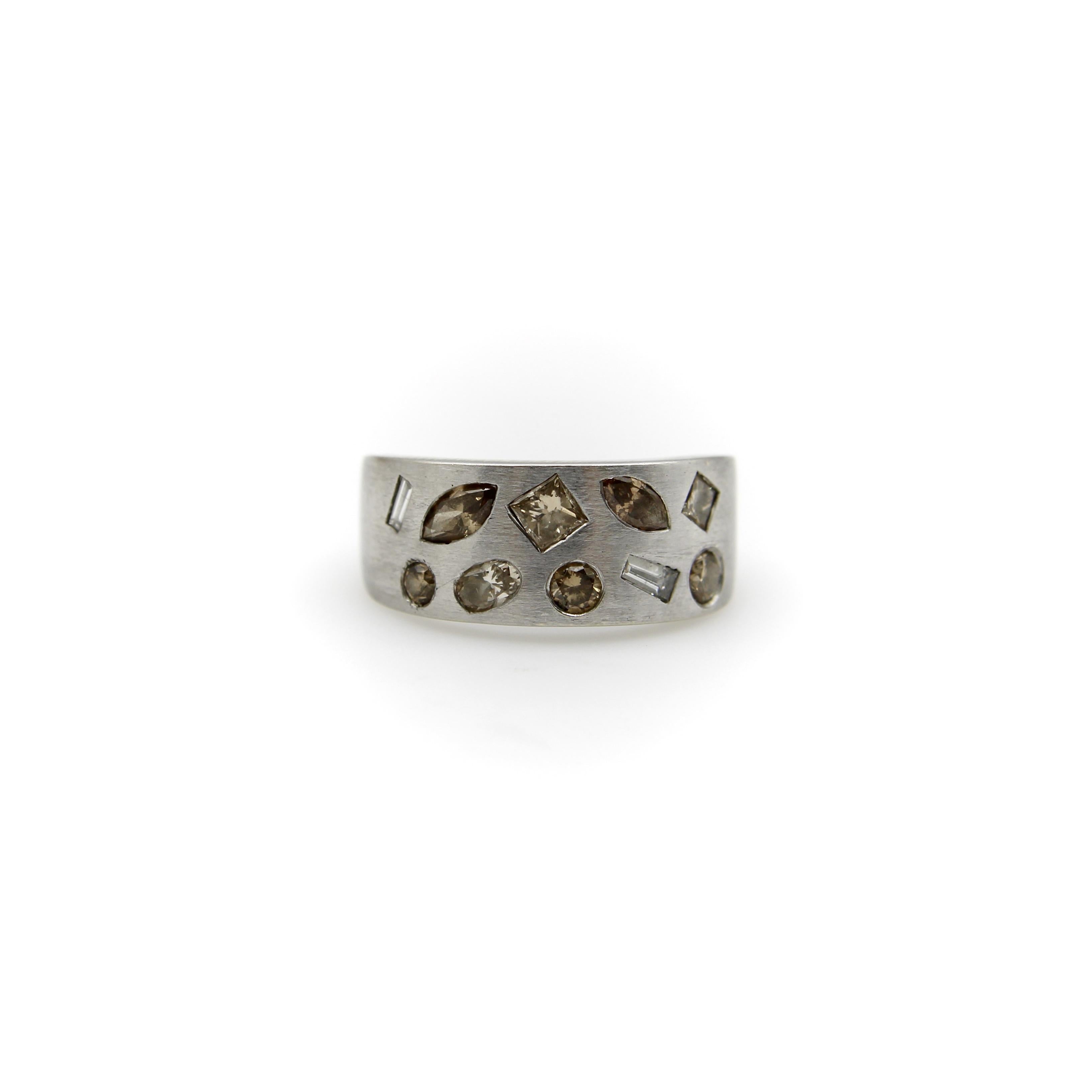 Ce magnifique bracelet en or blanc brossé 14k est incrusté de diamants de différentes formes, tailles et couleurs. La bague contient dix diamants de taille princesse, ronde, carrée, baguette effilée, baguette, marquis et moval. Les diamants de