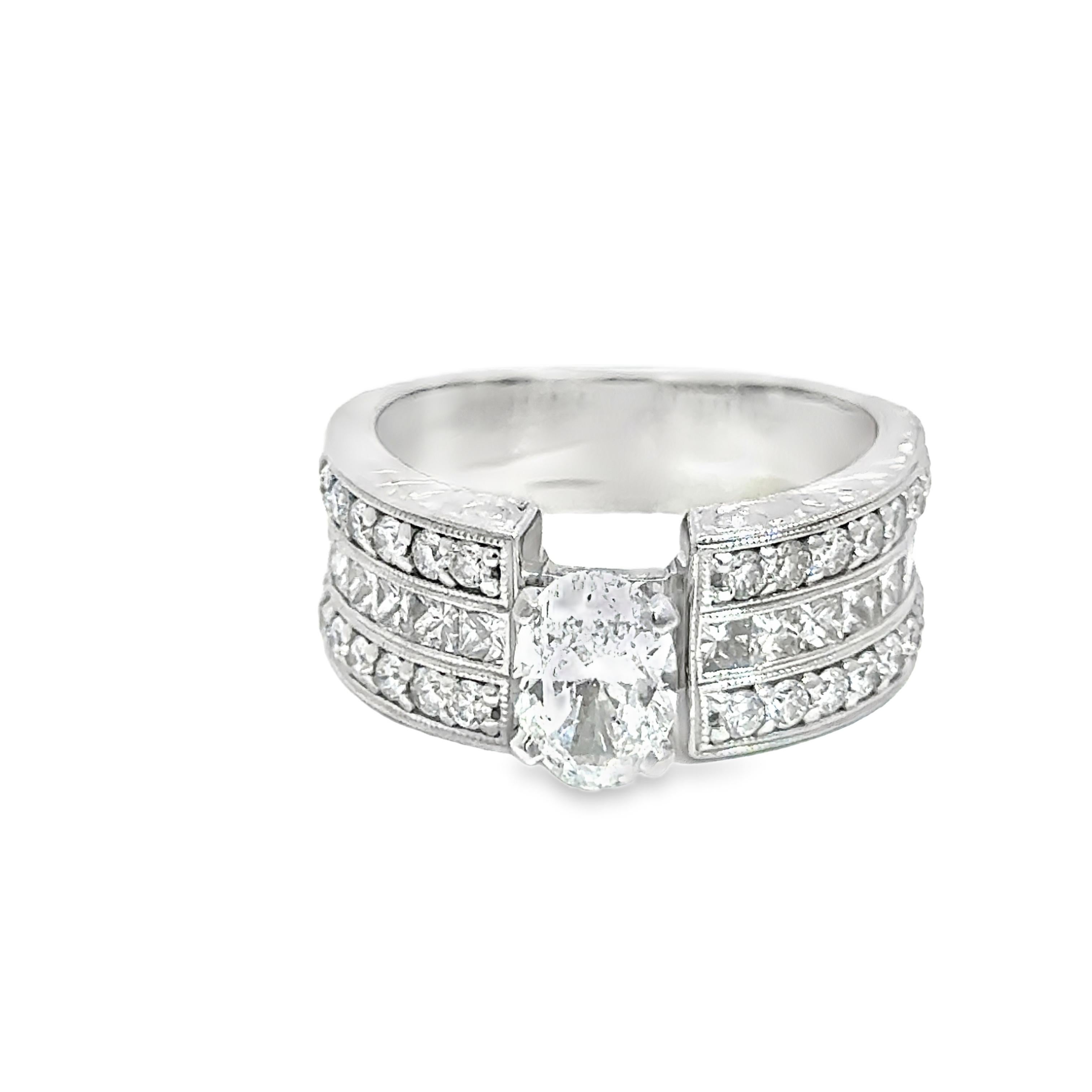 Cette bague en or blanc 14 carats est ornée d'un diamant central de 1,20 ct EGL SI1-D, flanqué de 1,10 ct de diamants de taille princesse et de 0,92 ct de diamants ronds. Les pierres serties de manière experte maximisent la brillance et le feu sous