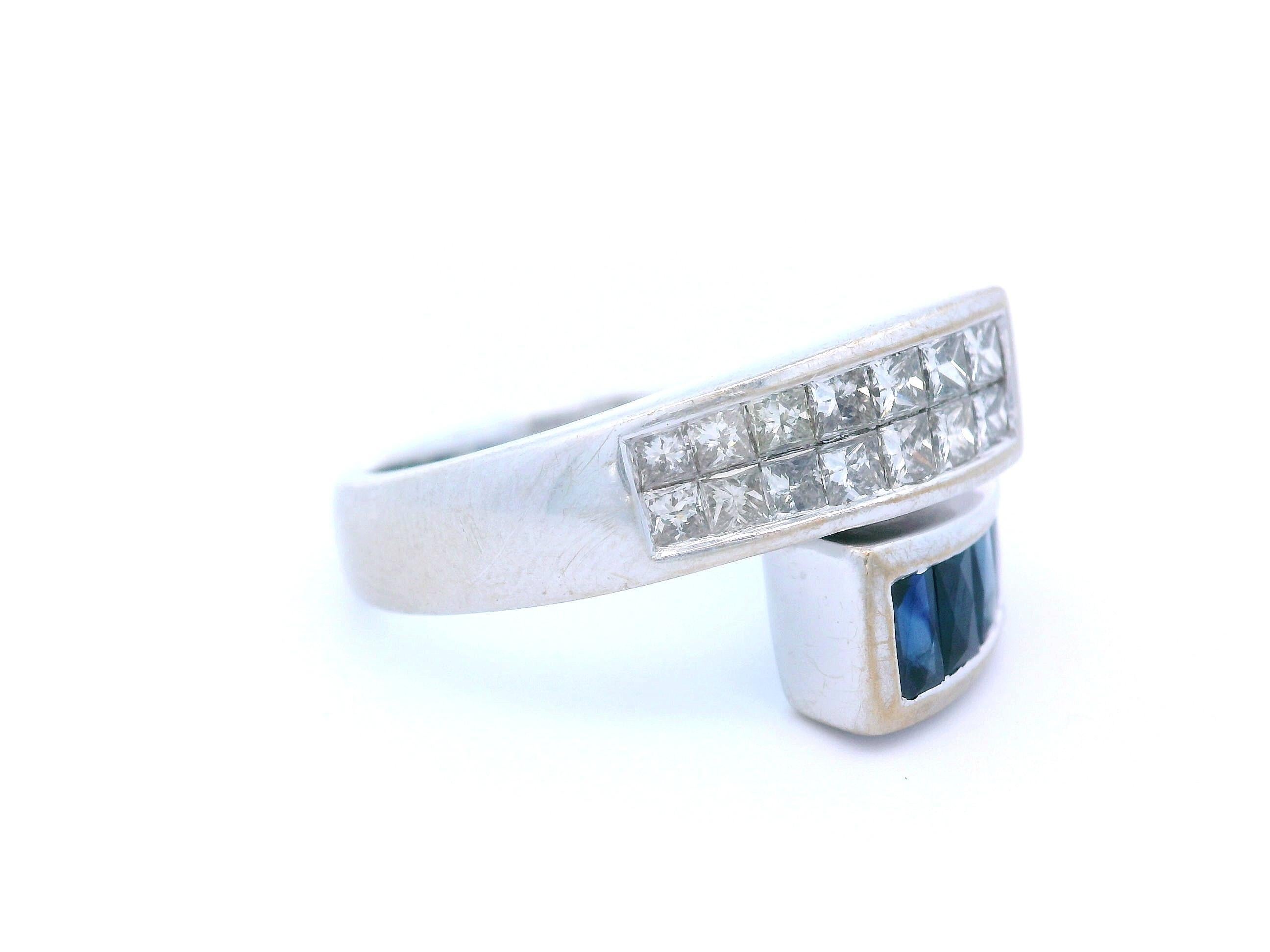 Cette magnifique bague bypass est réalisée en or blanc 14k et met en valeur des saphirs bleus naturels et des diamants. D'un côté du bypass se trouvent 7 saphirs rectangulaires de taille française, pour un poids total de 0,75 carats, ainsi que 14