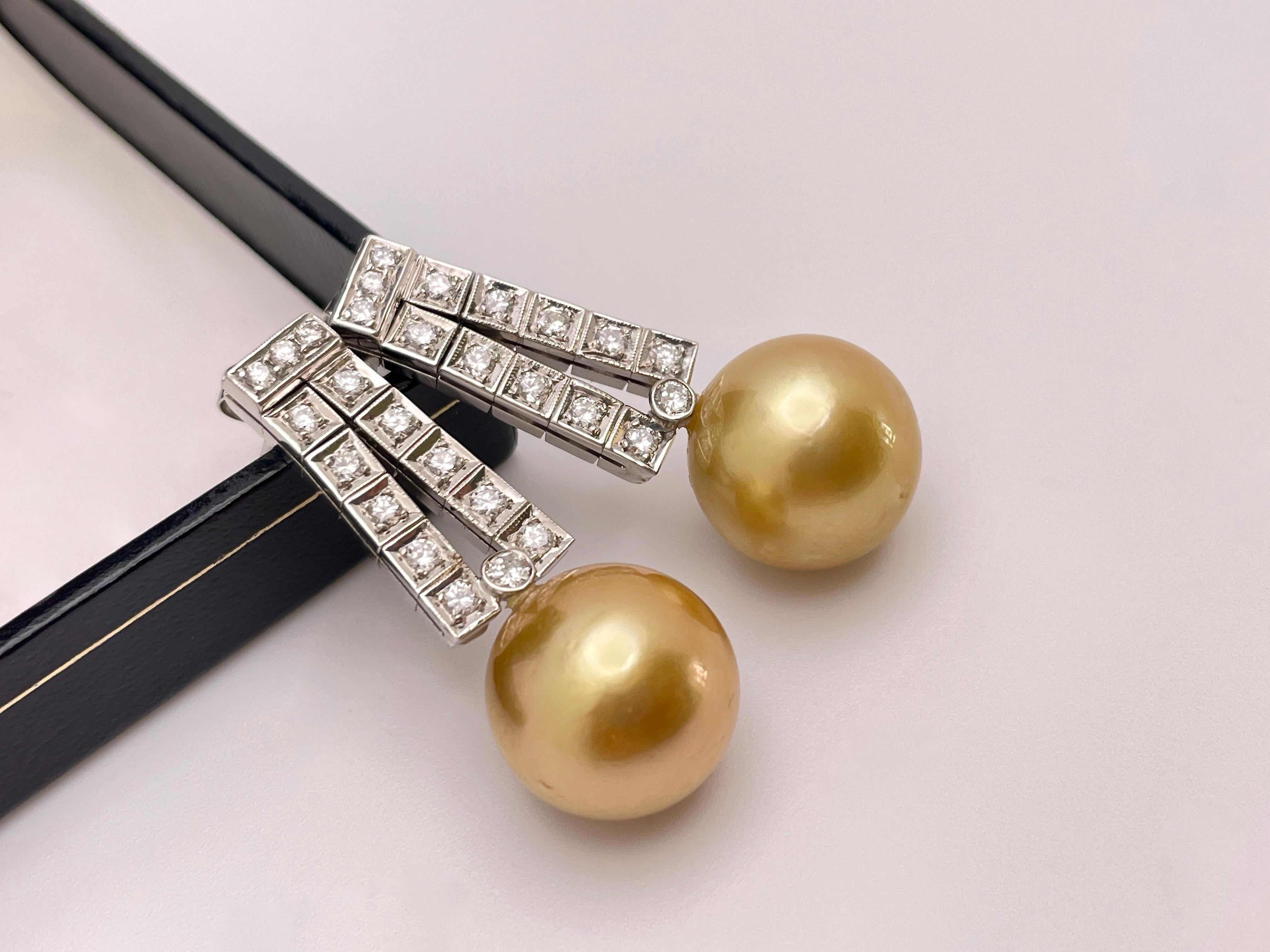 An original pair of 14K white gold diamond and natural yellow Australian pearl drop/dangle earrings. Each pair is set with 14 diamonds weighing approximately 0.50 CT and mounted with a natural yellow 13.30 MM Australian golden pearl. 

Gross Weight