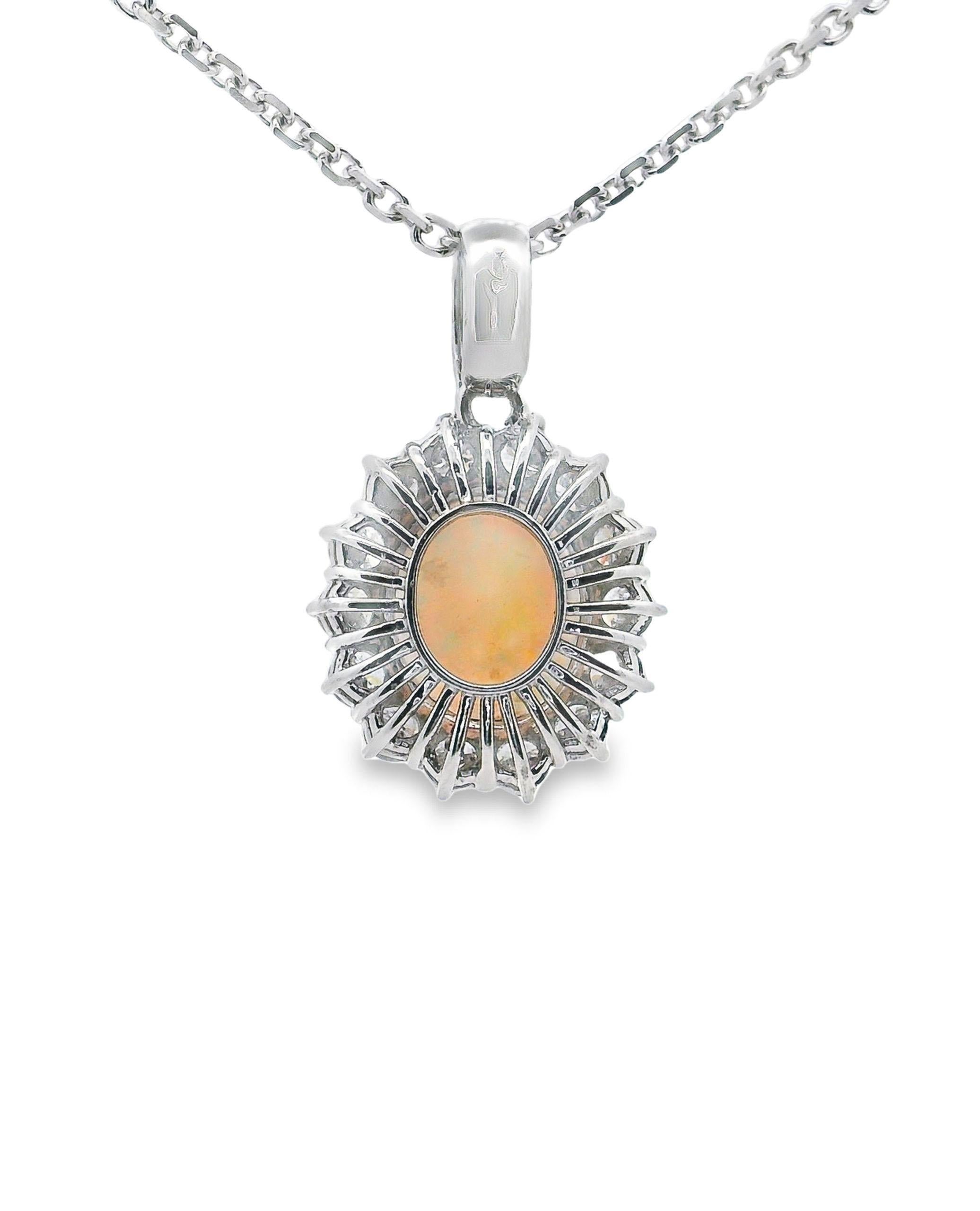 14K white gold pendant furnished with a halo of 14 round, brilliant-cut diamonds weighing 1.86 carats total. Featured in the center is one 11x14mm oval opal weighing 3.60 carats. The pendant slides on a diamond cut cable chain, 16 inches long.