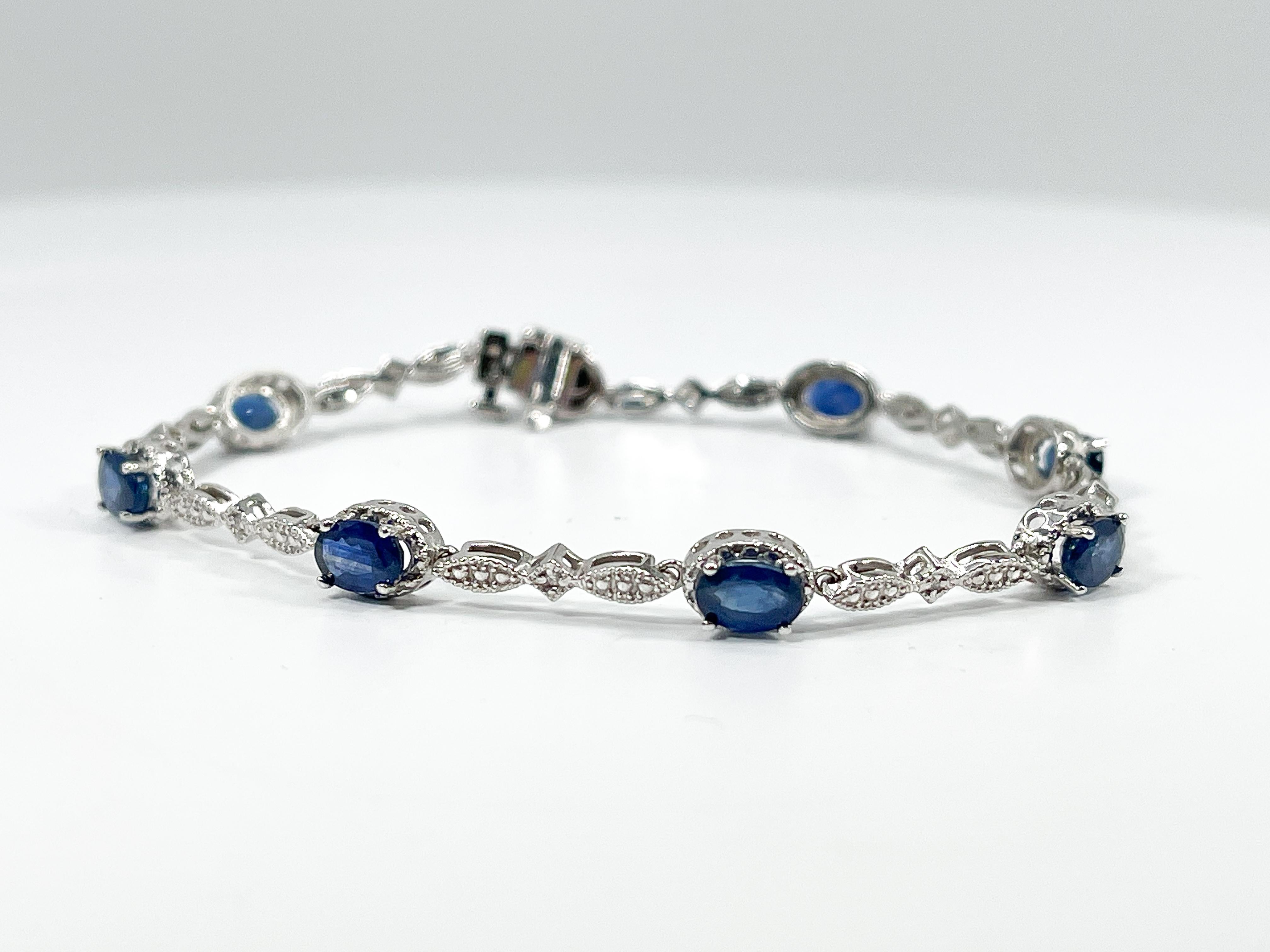14k white gold oval 5.20 CTW sapphire and diamond line bracelet. Bracelet has 8 diamonds and 8 sapphires and a tongue clasp with a safety bar underneath. The bracelet measures 7 inches, and has a weight of 7.85