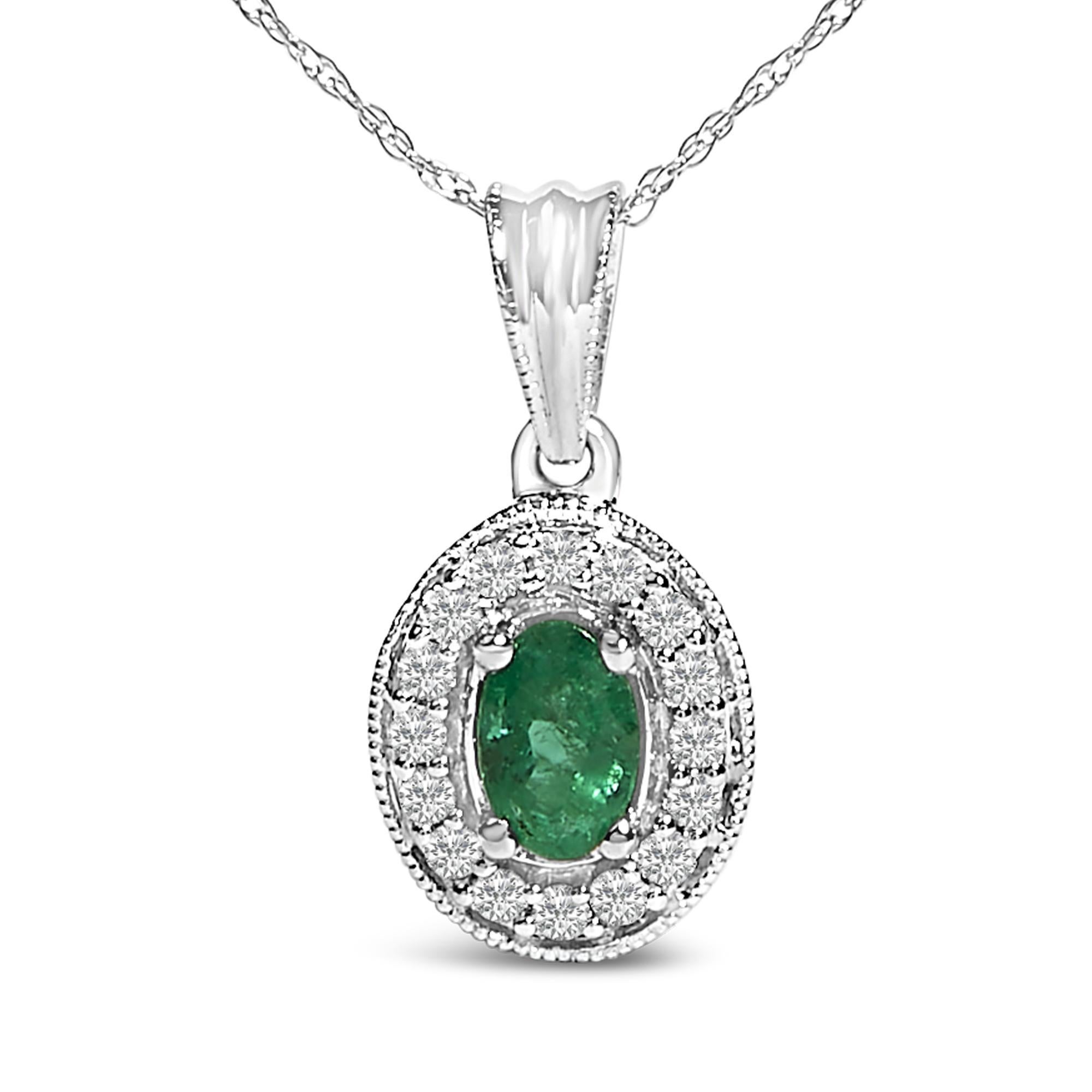 Enveloppez votre décollet�é du charme verdoyant de ce collier enchanteur, méticuleusement réalisé en or blanc rhodié 14K. En son cœur se trouve une lumineuse émeraude naturelle de taille ovale, mesurant 6x4 mm, dont la couleur est renforcée par un