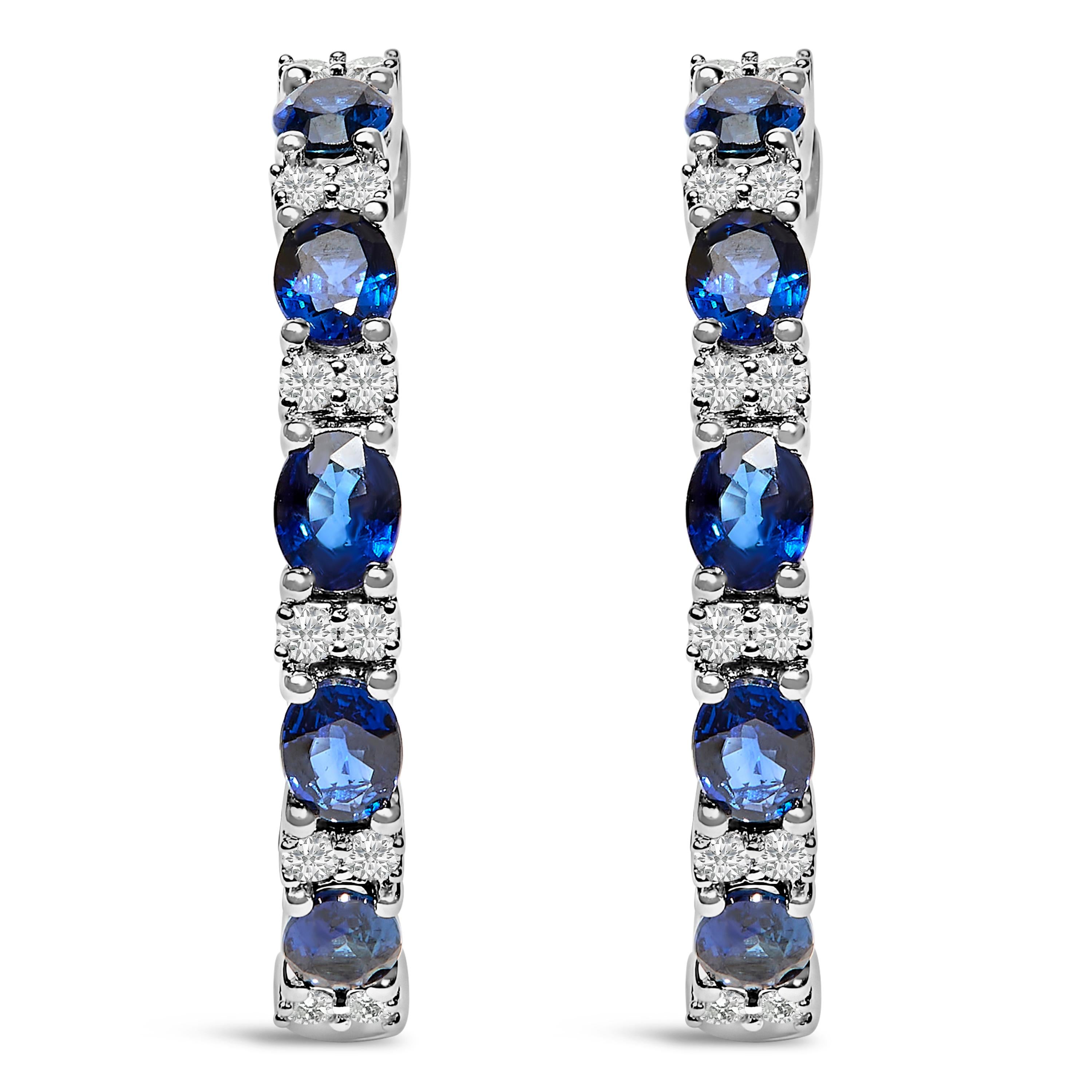 Immerse yourself in the elegance of these 14K white gold hoop earrings, masterfully rhodium-plated for a mirror-like shine. Enchantingly delicate, each hoop dances with the deep, endless blue of natural sapphires and the scintillating radiance of