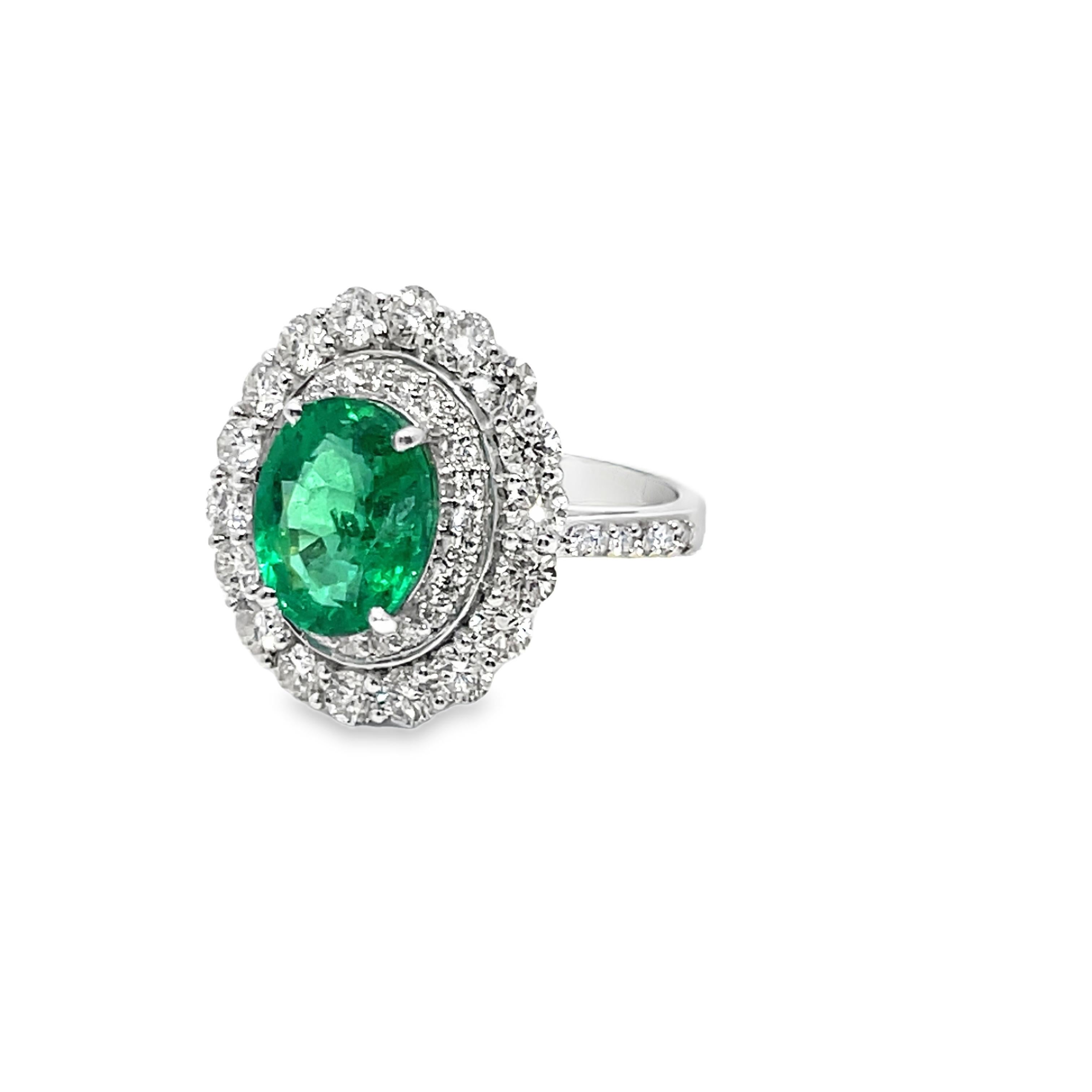 Realizzato in oro bianco 14 carati, questo squisito anello presenta al centro uno smeraldo di 2,75 ct. con diamanti rotondi a taglio brillante di 1,65 ct. che formano un'aureola intorno ad esso. l'aureola interna è composta da diamanti più piccoli e