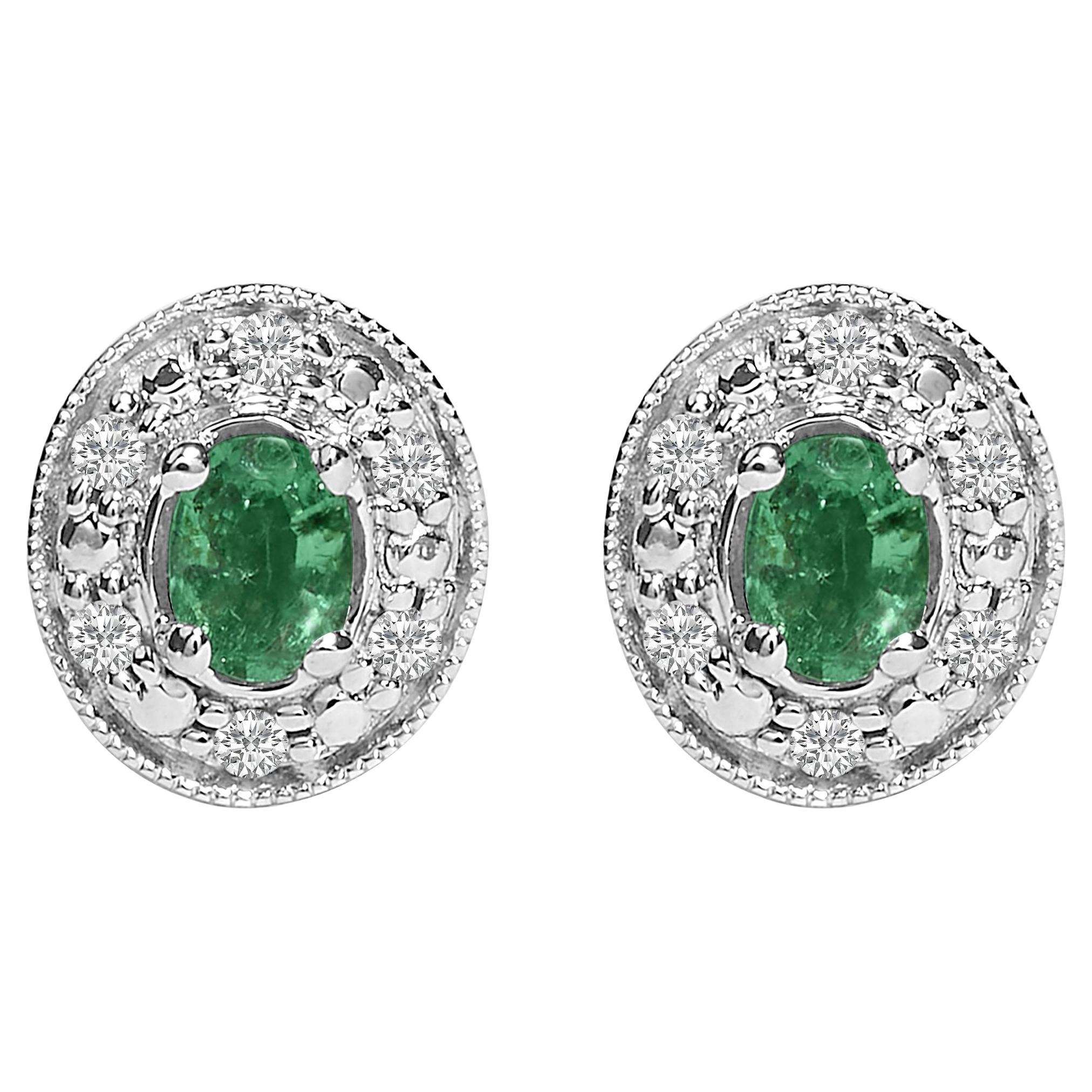 Pendientes de oro blanco de 14 quilates con esmeralda verde ovalada y halo de diamantes de 1/10 qt