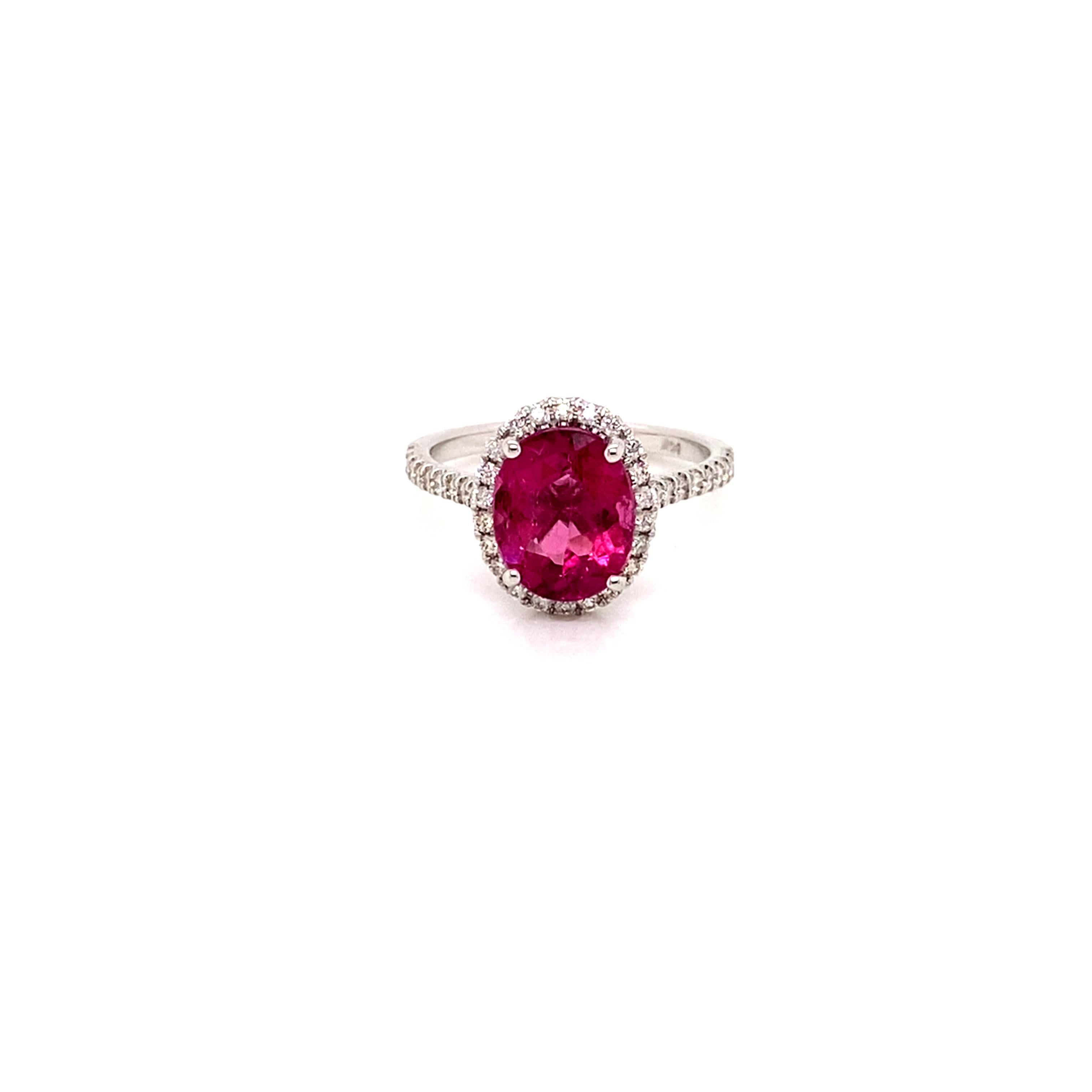 A vibrant pink 3.26 carat Oval  Pink Tourmaline with a scintillating halo of brilliant diamonds on a diamond band make quite the dazzling statement.
This stunning tourmaline was hand selected for its brilliance, clarity, and  youthful vibrant pink