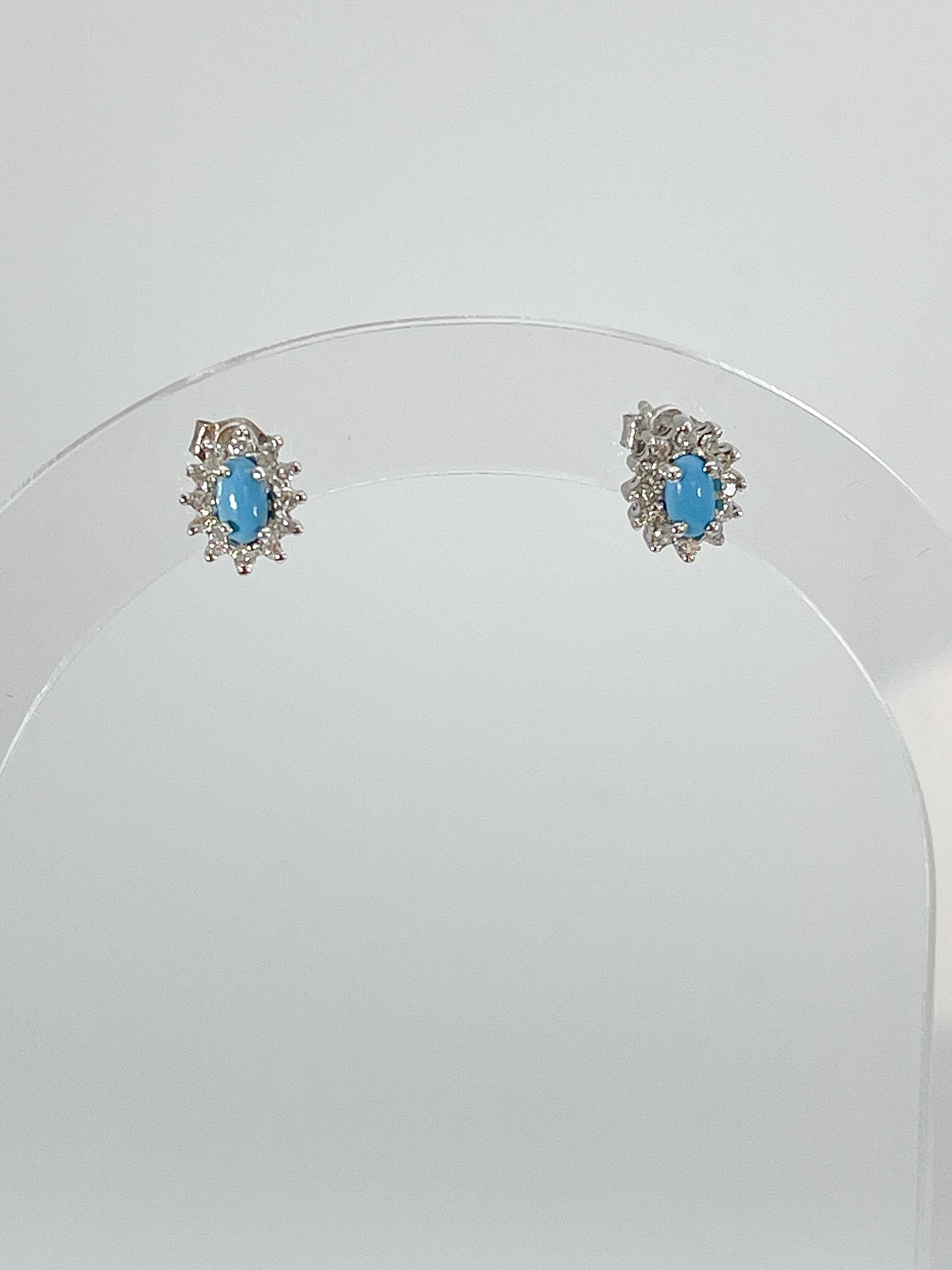 14k white gold oval turquoise and diamond stud earrings. The diamonds are all round, measurements of these earrings are 8.8 x 7.3 mm, and have a total weight of 1.7 grams.