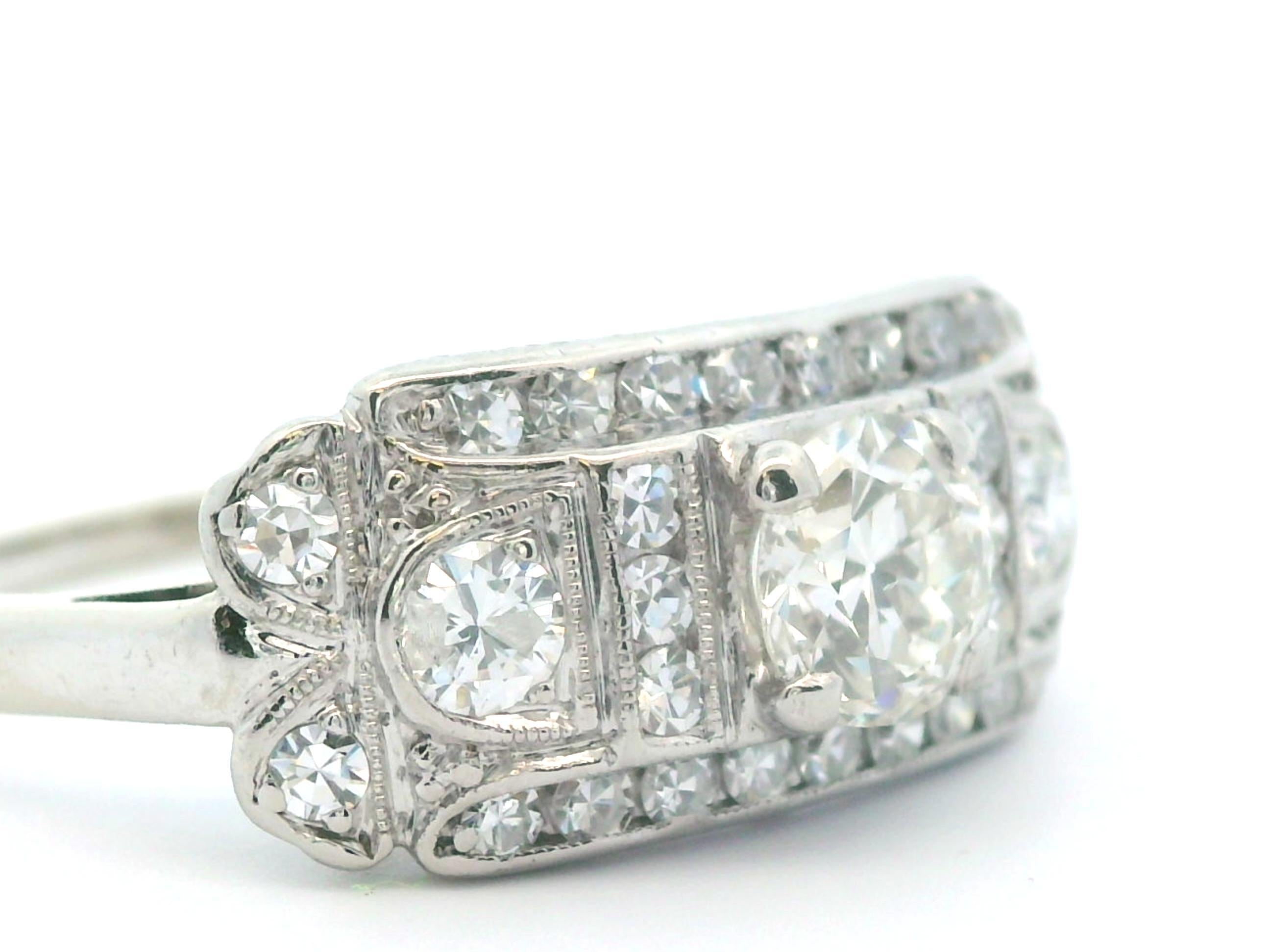 Questo splendido anello con diamante è realizzato in oro bianco 14k e palladio. Al centro dell'anello si trova uno scintillante diamante a taglio rotondo da 0,51 carati, con due diamanti a taglio rotondo più piccoli a sinistra e a destra. Tutti e