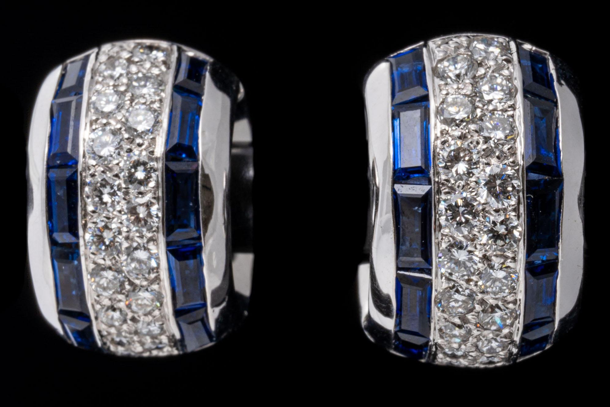 14k white gold earrings. These stunning earrings are a chubby huggie hoop style, decorated with a center row of pave set, round brilliant cut diamonds, approximately 0.64 TCW, and flanked with rectangular faceted, medium to dark blue color