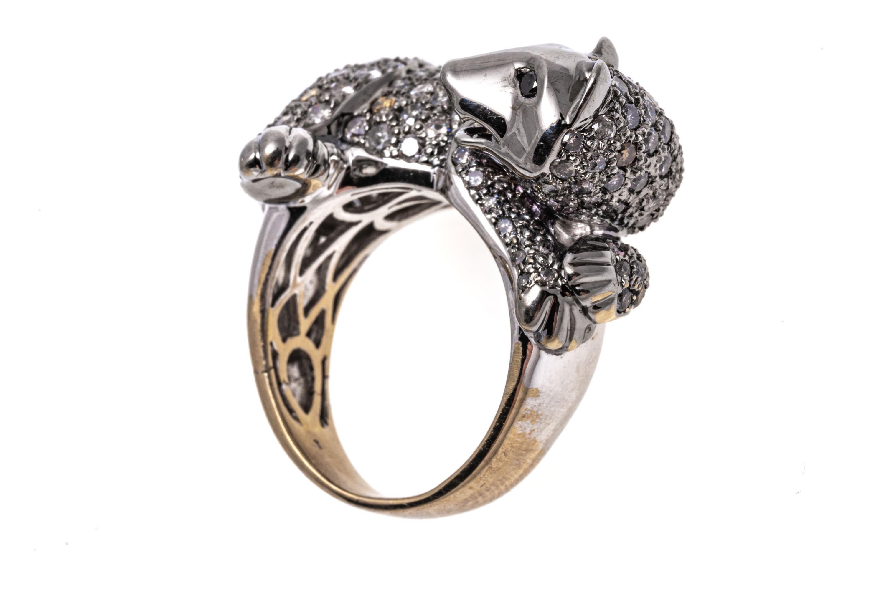 14k gold ring. This fun and quirky ring is a white gold, figural honey badger, pave set with round faceted,  diamonds, approximately 1.52 TCW. The ring is finished by round faceted, black diamond eyes, approximately 0.02 TCW and a yellow gold