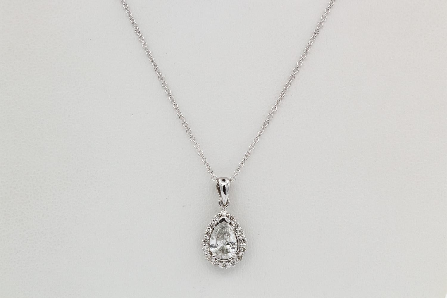 We are pleased to present this 14k White Gold & Pear Diamond Halo Pendant Necklace. This cute piece features a 0.93ct I-J/I1-I2 pear cut diamond set in a 14k white gold halo pendant with 0.24ctw round brilliant cut diamonds on a 14k white gold