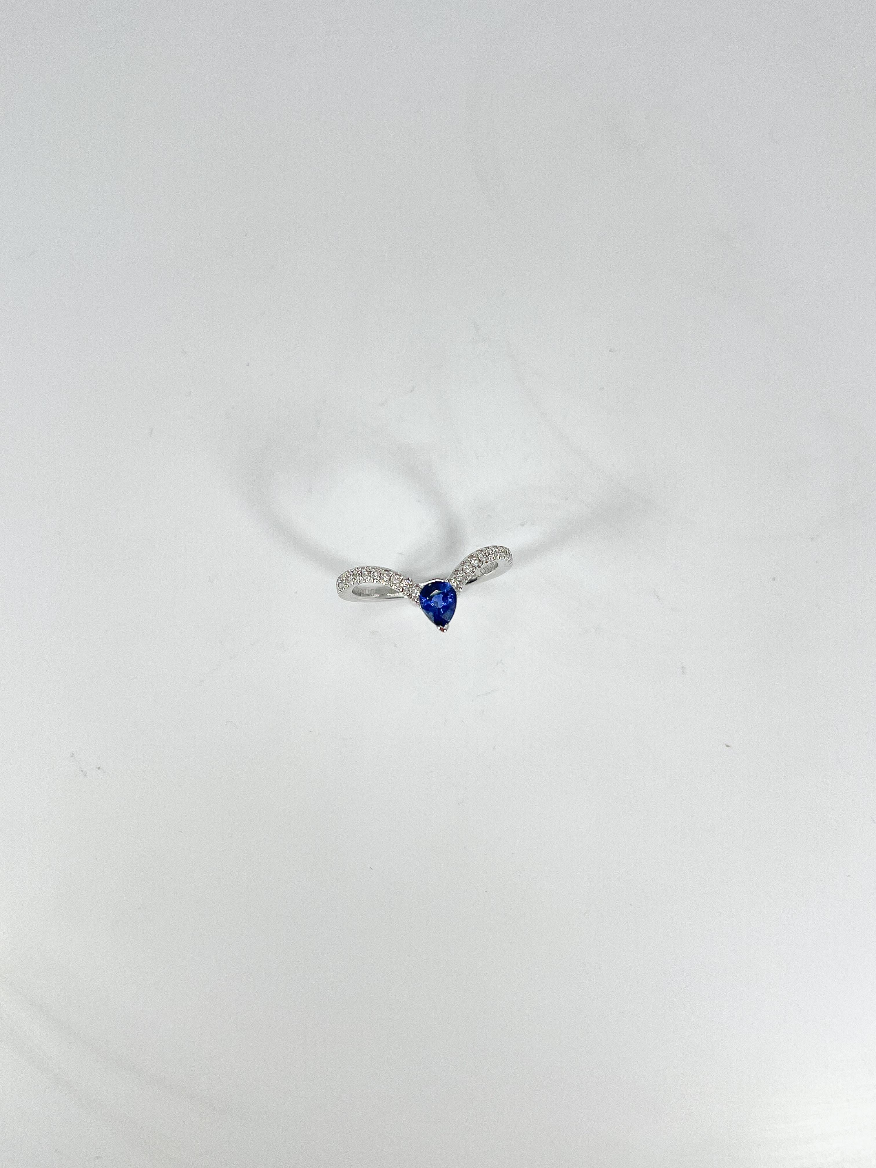 14k white gold pear sapphire and diamond V shaped ring. Pear sapphire as the center stone, measures 6 x 4 mm, diamond side stones that go halfway down the shank. The ring is a size 6 1/4 and has a total weight of 2.35 grams.