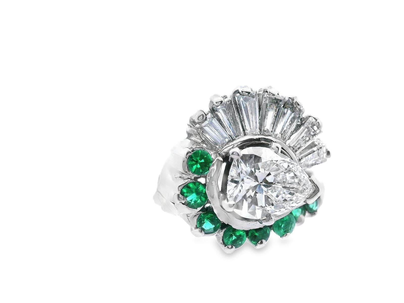 Dieser wunderschöne Cocktailring aus Weißgold stammt aus den 1950er Jahren und zeigt einen unglaublichen birnenförmigen Diamanten, der von Baguetten und leuchtend grünen Smaragden umgeben ist. Der Ring wird mit einem GIA-Gutachten für den