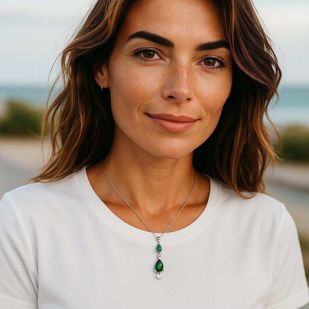 Élevez votre élégance quotidienne avec ce collier raffiné en or blanc 14 carats, orné de deux émeraudes en forme de poire assorties, totalisant 0,70 carats, gracieusement suspendues dans un design de goutte verticale. Un seul diamant rond brillant