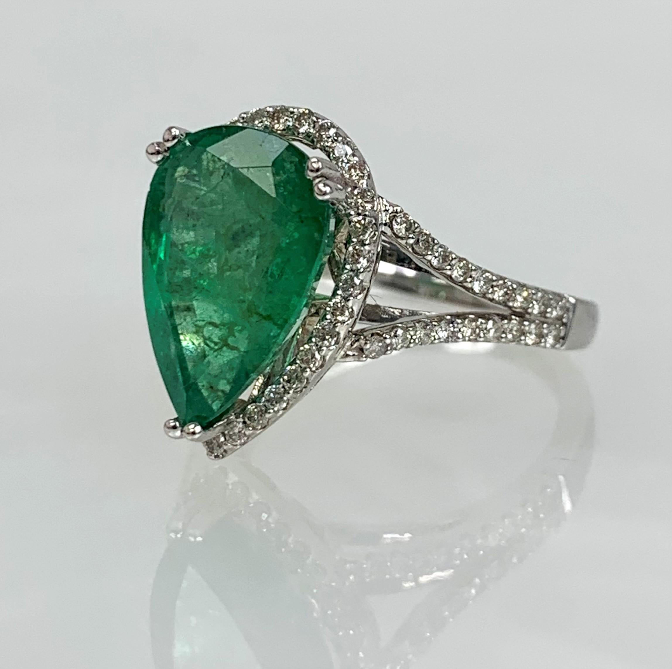 A timeless and noticeable emerald ring featuring a pear shaped center stone weighing 4.36 carats accented by 0.46 carats of white diamonds set in solid 14k white gold with intricate heart shaped detailing beneath the stone.

*Approximate stone