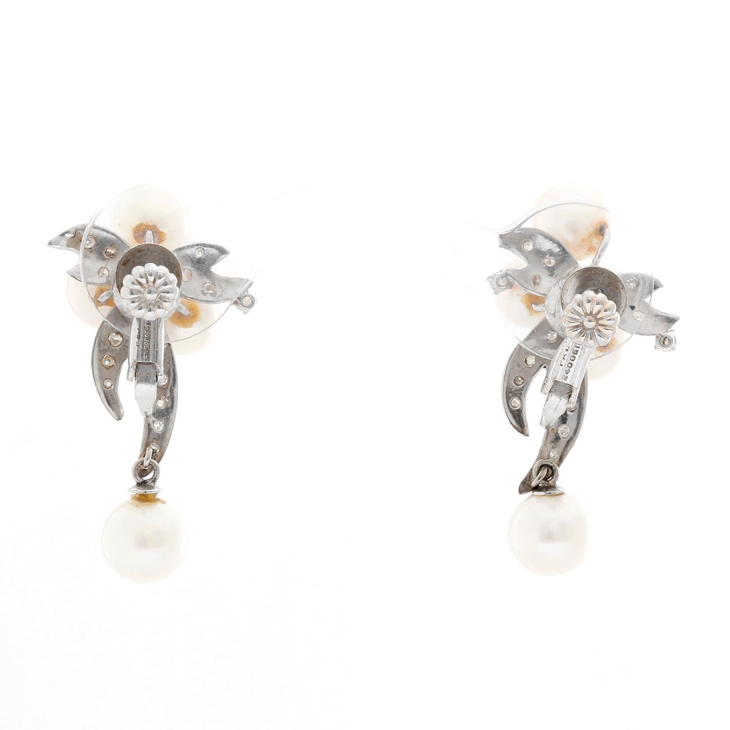 14K White Gold Pearl and Diamond Earrings - Beautiful bow like earrings set in 14K White Gold with four pearls. Total weight 9.8. Total length 1 inch and a half. One dangling pearl. The perfect wedding earrings .