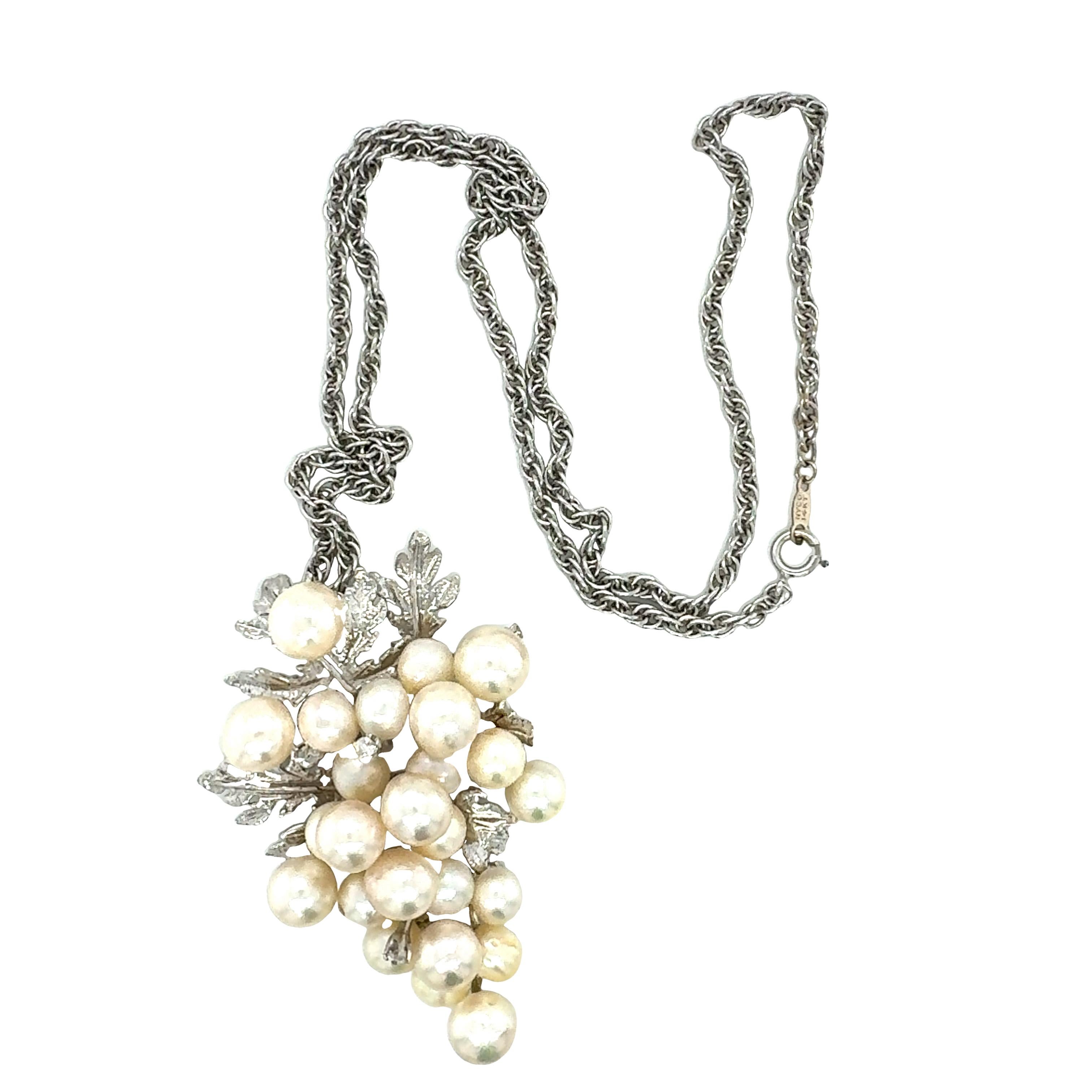 Un pendentif grappe de perles en or blanc 14 carats comprenant 25 perles de culture blanches rondes mesurant de 6,00 à 8,00 millimètres de diamètre. Accentué par deux diamants ronds de taille brillante sertis à l'emporte-pièce totalisant 0,06 ct. de