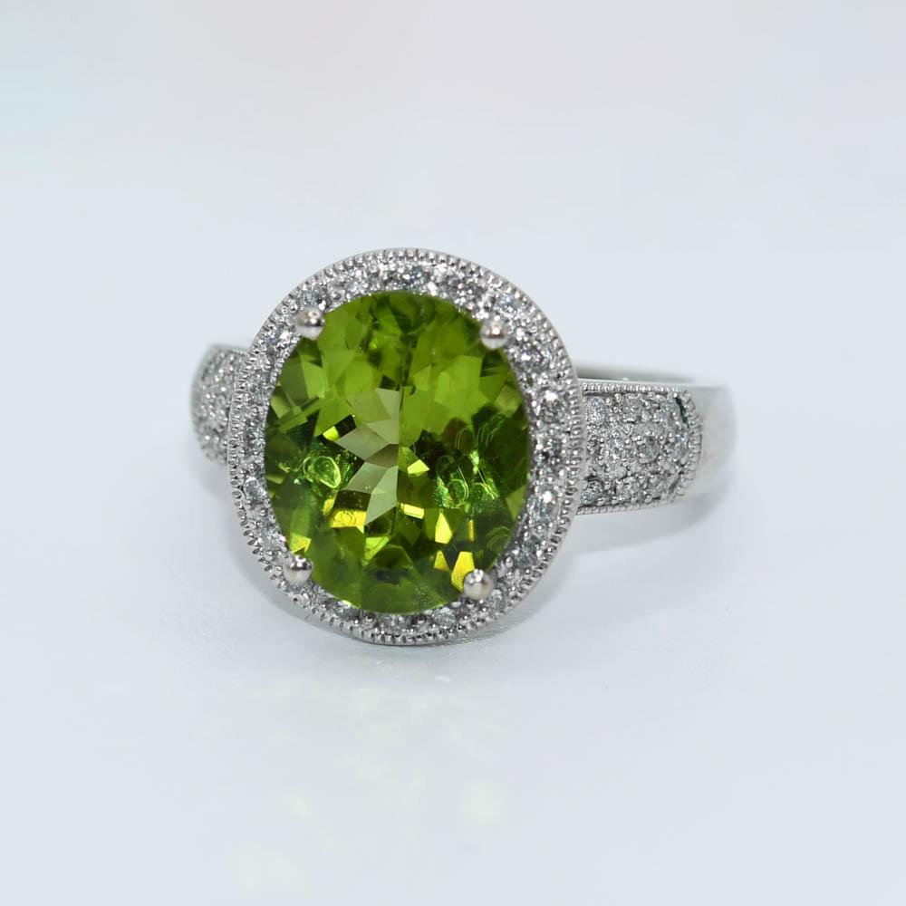Ladies peridot and diamond ring with 14k white gold setting.
Stamped 14k and weighs 6.4 grams.
The peridot is an excellent yellowish-green color, oval shape, fancy faceting, approximately 4.80 carats.
Under 10 power magniification you can see some