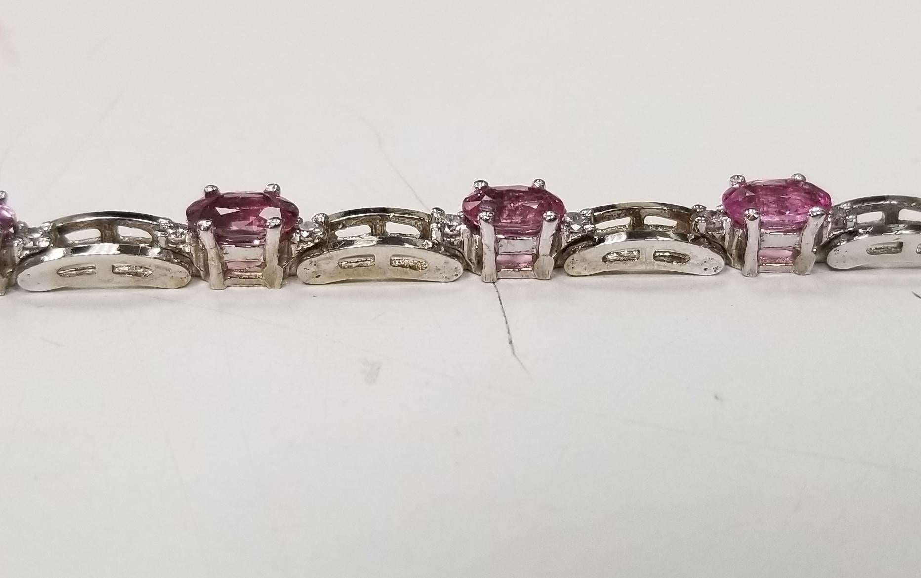 14k white gold pink tourmaline and diamond bracelet, containing 11 oval cut pink tourmaline of gem quality weighing 6.15cts. and 22 round full cut diamonds; color 
