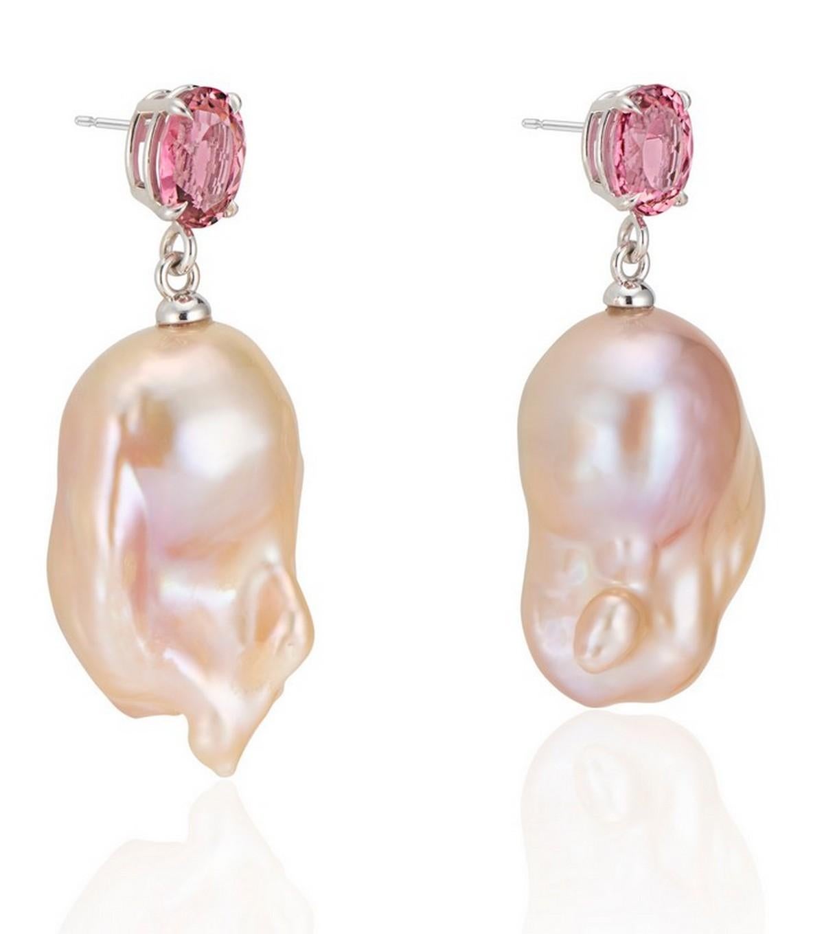 Vibrant Pink Tourmaline set in a high polish 14K white gold basket setting paired with a natural color pink/golden hue baroque pearl drop.

The vibrant color of the tourmaline draws out the pinkish hue in these natural colored freshwater baroque