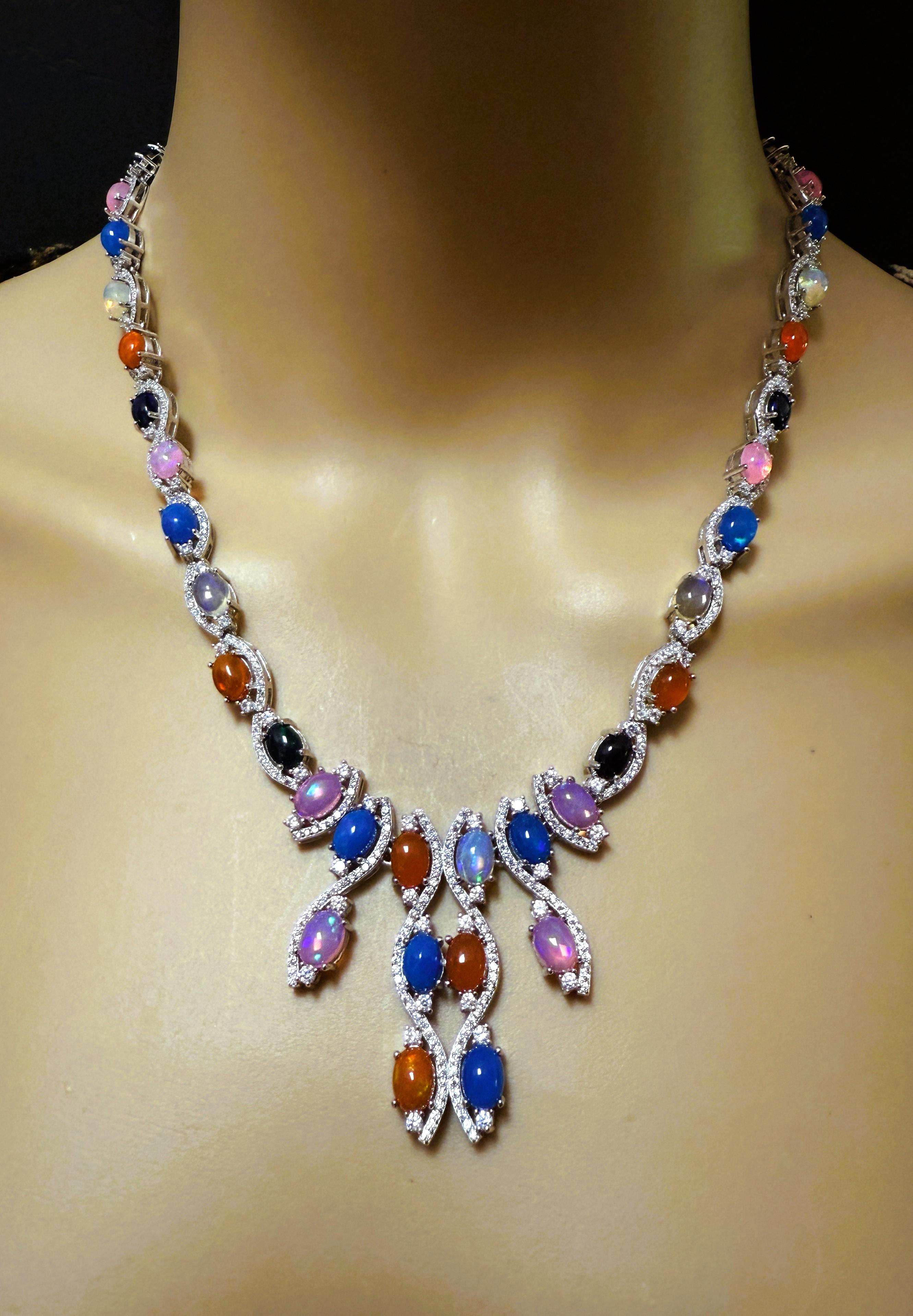 Este collar es precioso.  Es una pieza muy versátil porque tiene varios ópalos de distintos colores.  Tiene 42 ópalos que miden 7 x 5 mm.  Están rodeados de zafiros talla diamante.  El collar es ajustable de 17 a 18,25 pulgadas y mide 0,25 pulgadas