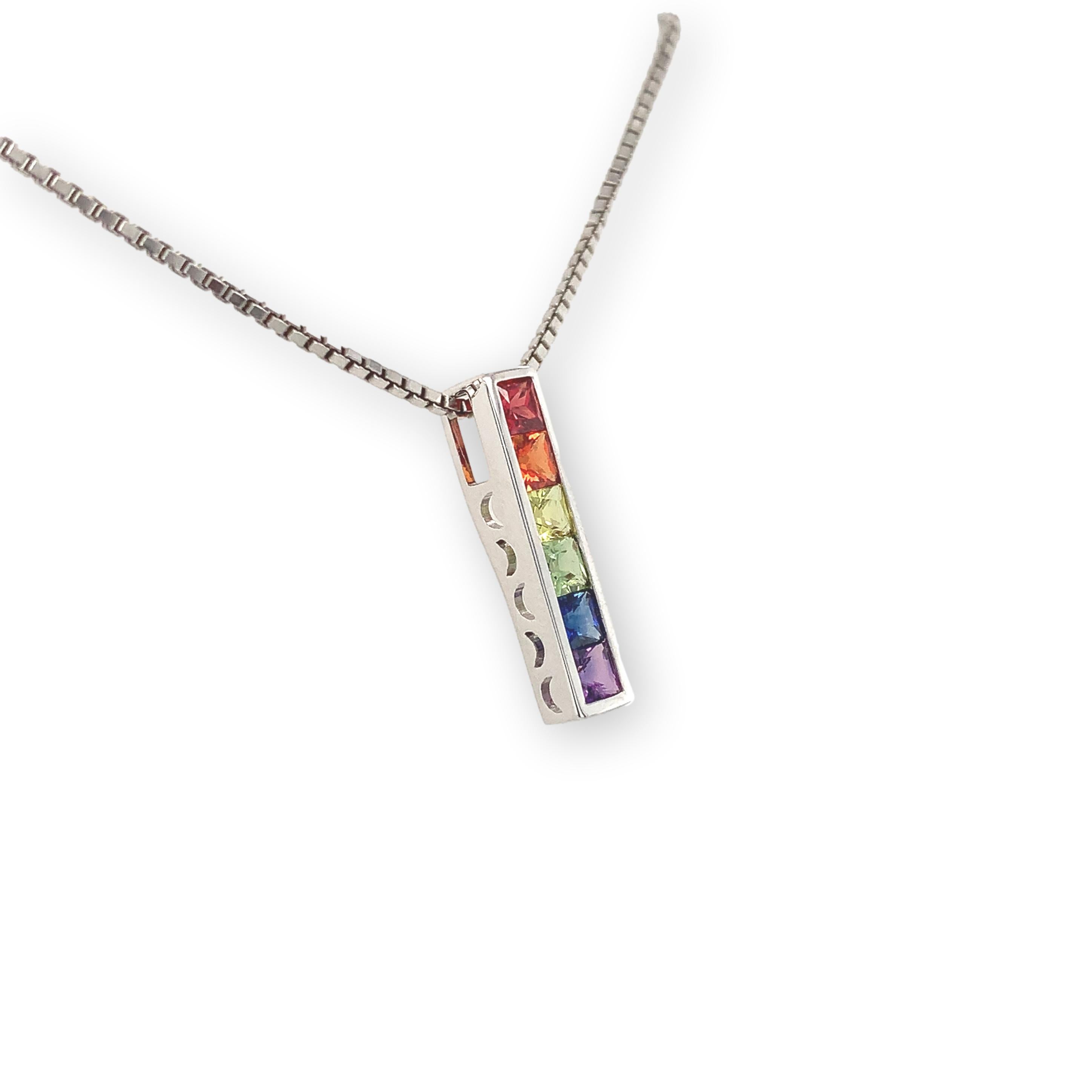 14K Pendant with 6 princess cut sapphires weighing 1 carat total arranged into a rainbow. The sapphires are princess cut and measure 2.8mm each. The sapphires have bold primary colors including blue, green, yellow, orange, pink and purple. The