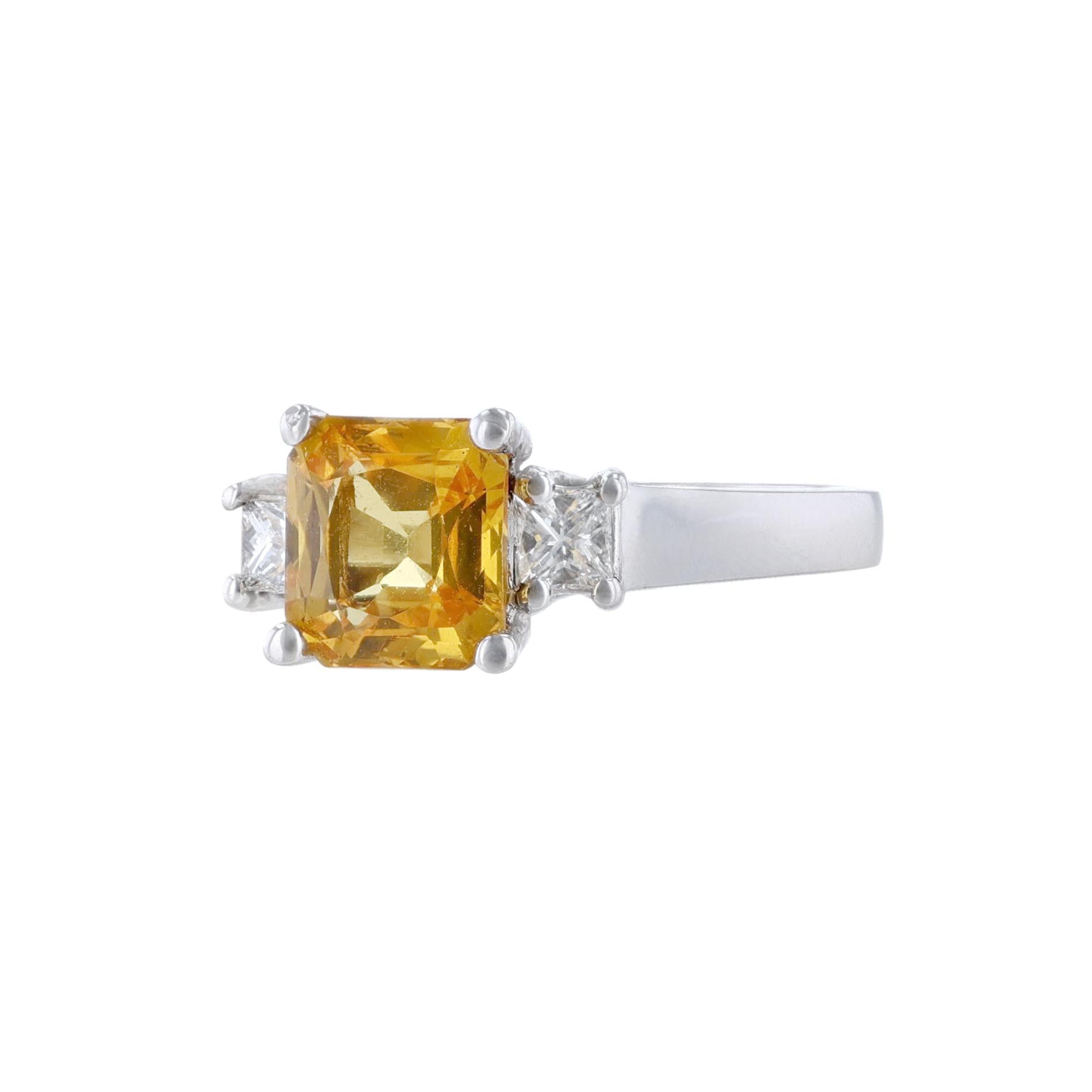 This ring is in 14K white gold. It features 1 princess-cut yellow sapphire weighing 1.88 carats. With 2 princess cut diamonds weighing 0.25 carats. With a color grade (H) and clarity grade (SI2). All stones are prong set.