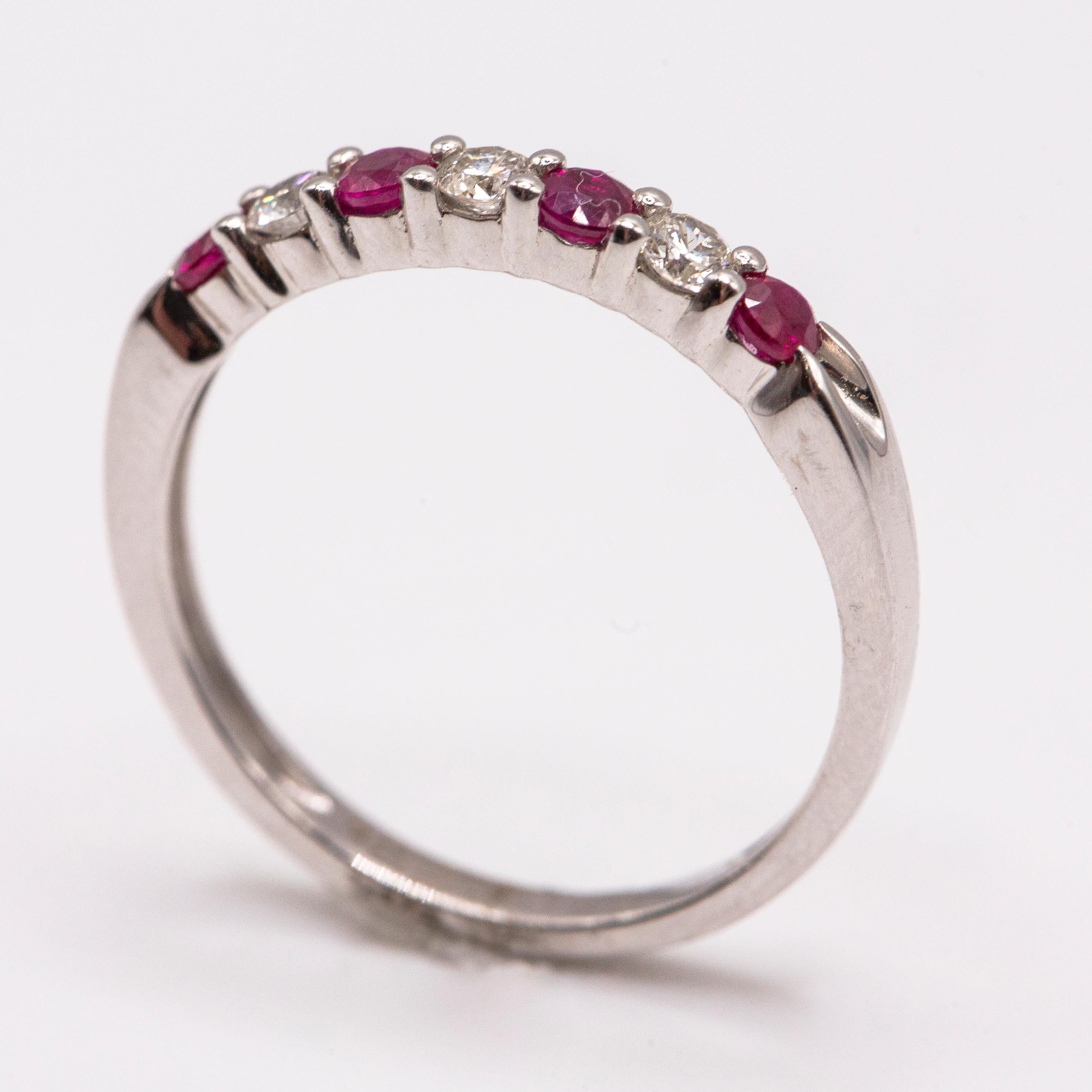  A 14k high polished contemporary band set with alternating fine white diamonds and deep, bright red natural rubies. Diamonds 0.10 carats total. Rubies 0.16 carats total.
