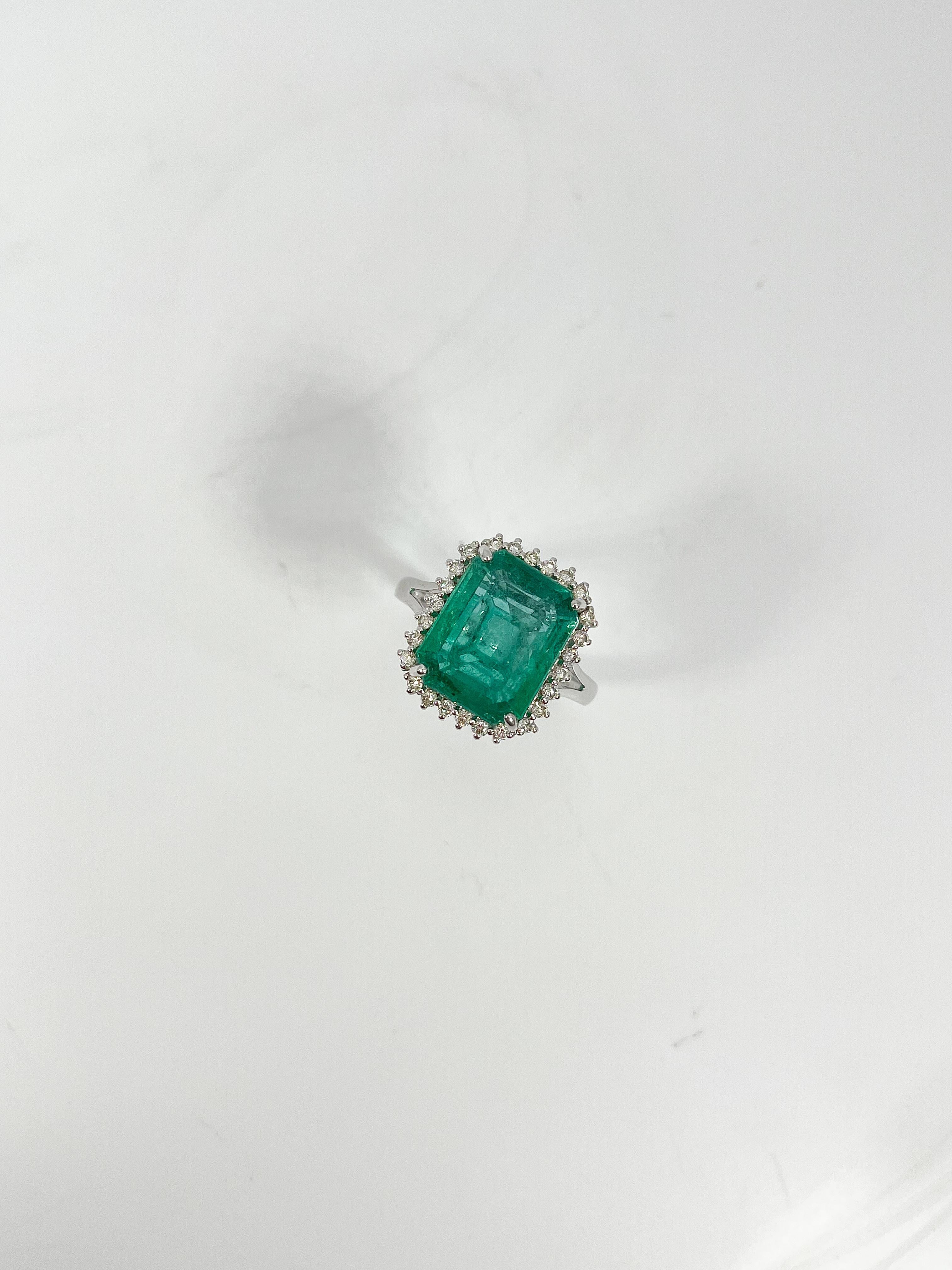 Bague pour femme de taille 7 en or blanc 14k avec émeraude montée dans une monture panier à quatre griffes. La bague contient également vingt-six diamants ronds de taille brillant montés en halo à l'aide de sertis à trois branches partagés. Le poids