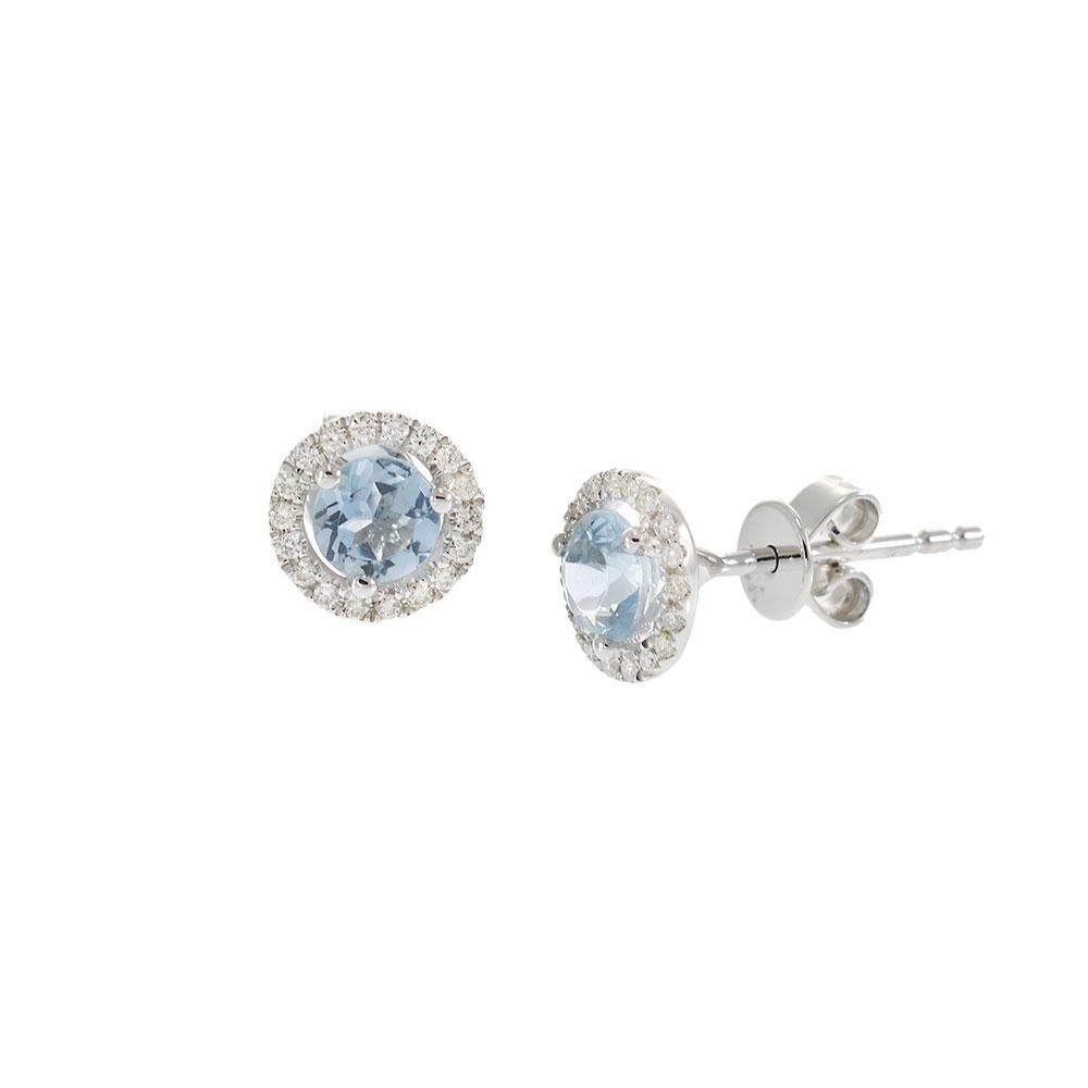 Questi luminosi orecchini con perno sono caratterizzati da morbide acquemarine blu per un totale di 0,65 carati, ciascuna circondata da una luminosa aureola di diamanti rotondi. Incastonato in oro bianco lucido 14 carati, il design rappresenta un