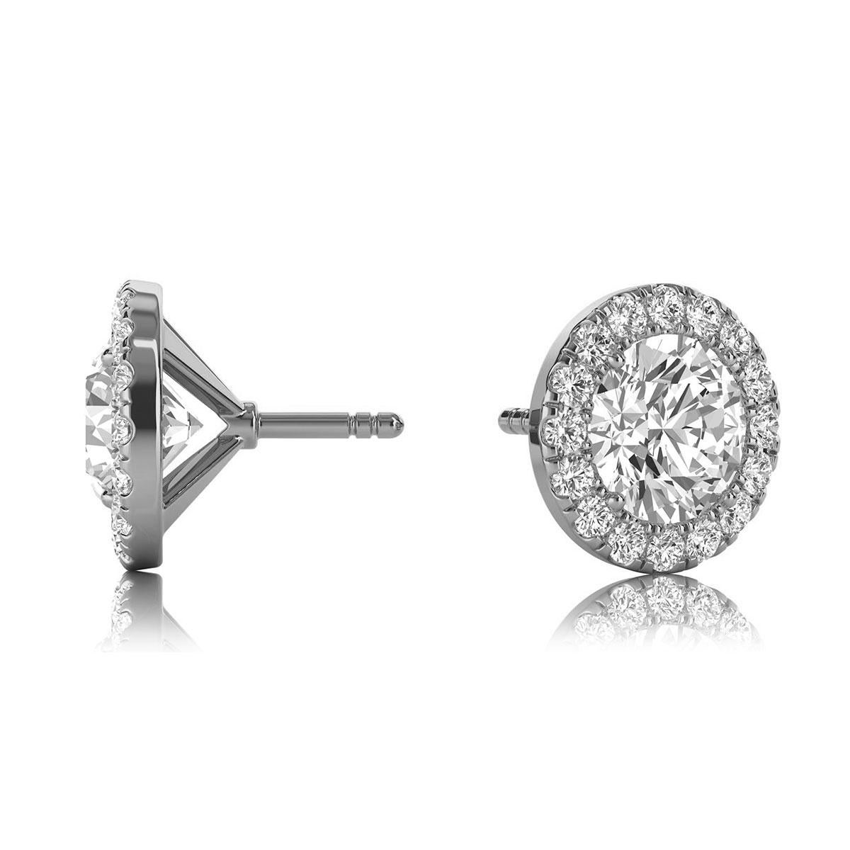 Questi delicati orecchini presentano due diamanti rotondi di circa 1,08 carati di peso totale (5,2 mm) circondati da un'aureola di 32 diamanti tondi taglio brillante perfettamente abbinati, per un peso totale di circa 0,32 carati. Gli orecchini