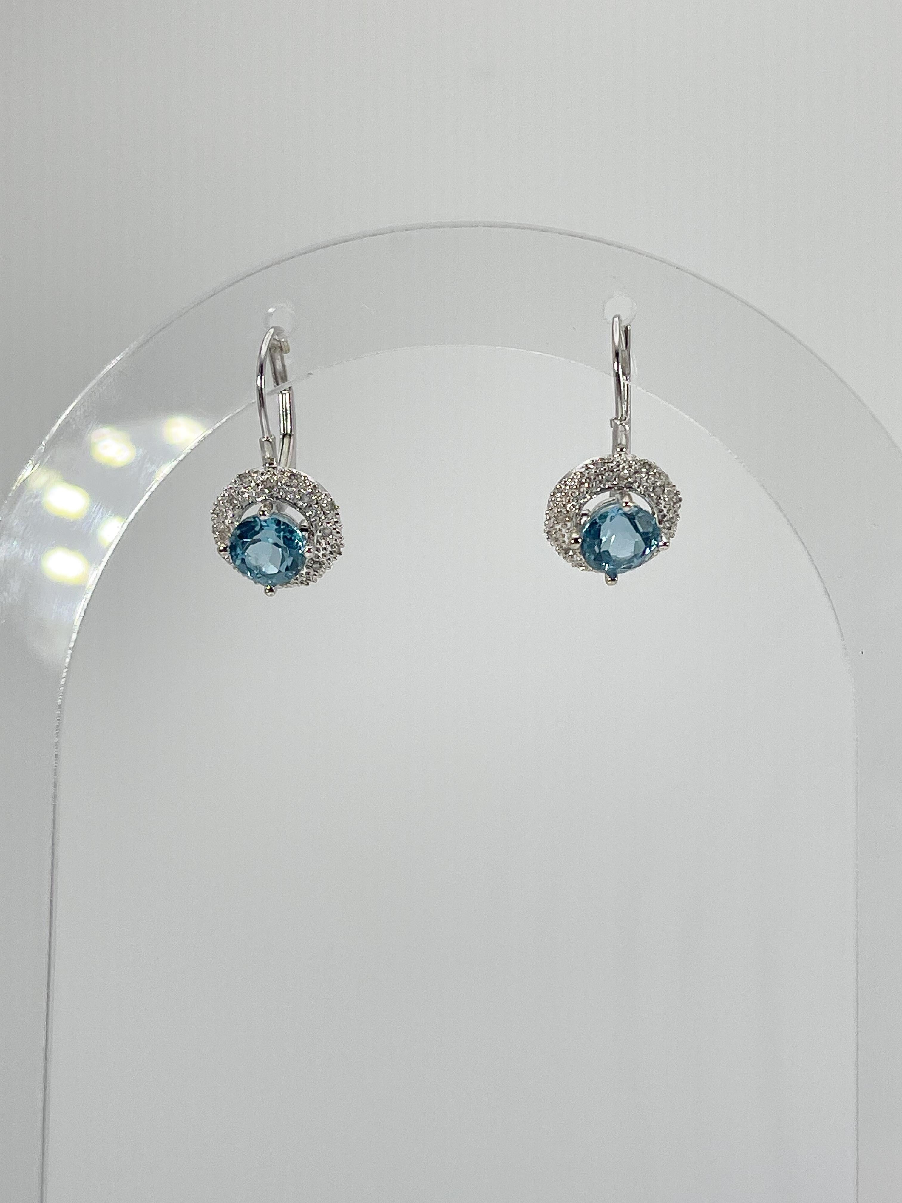14k white gold round Swiss blue topaz earrings. These earrings have a lever back for easy wearing. The diameter of the design is 8.3 mm, the total weight of the earrings is 2.79 grams. 