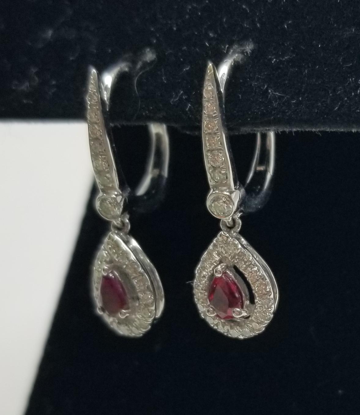 14k white gold ruby and diamond dangle earrings, containing 2 pear shape rubies of very gem quality weighing .30pts. and 48 round full cut diamonds weighing .50pts.
