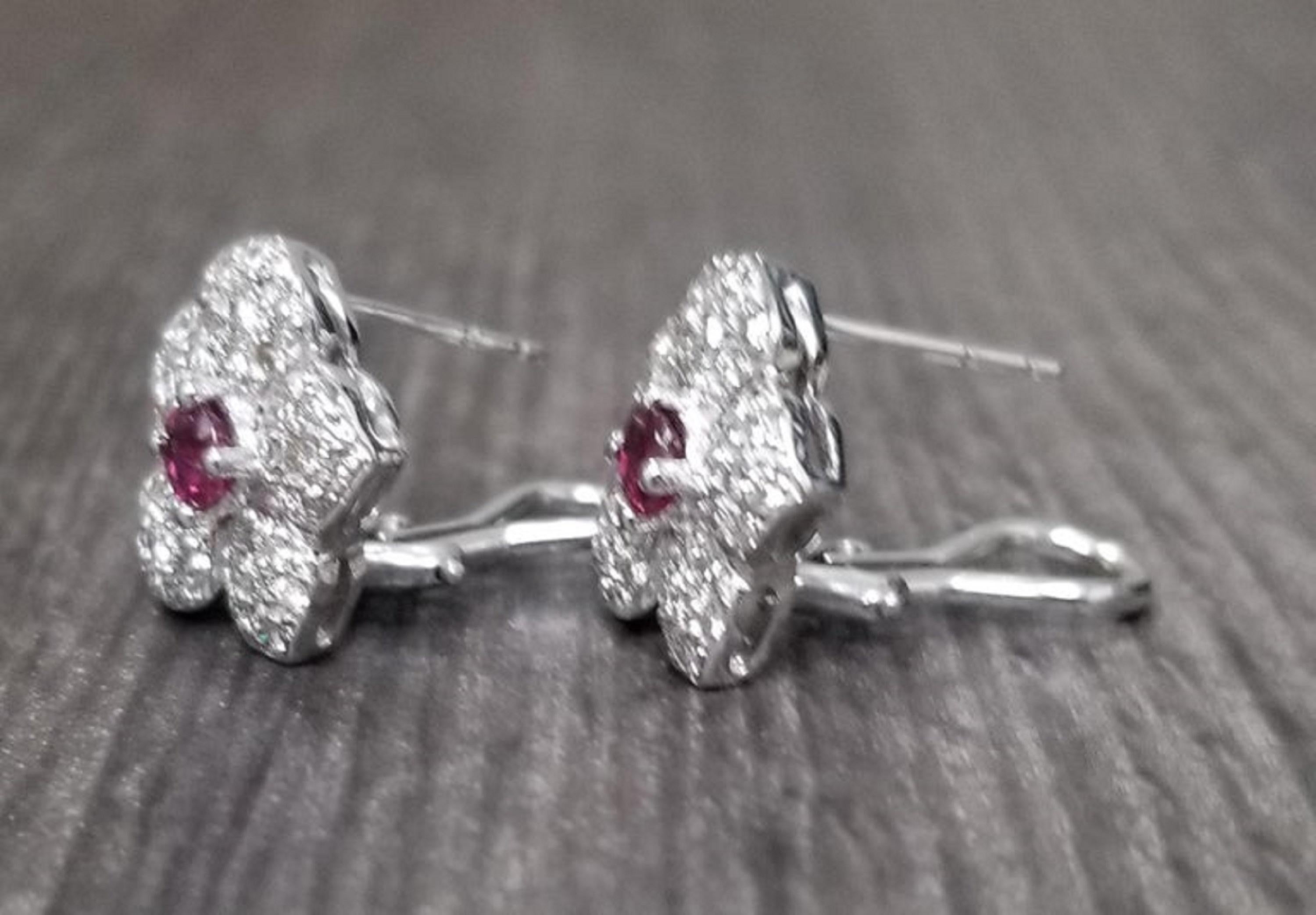 14k white gold ruby and diamond earrings containing 2 round rubies of gem quality weighing .46pts. and 70 round full cut diamonds of very fine quality weighing .80pts. paved in a floral with 14k white gold omega backs for comfort.
* pick a gemstone