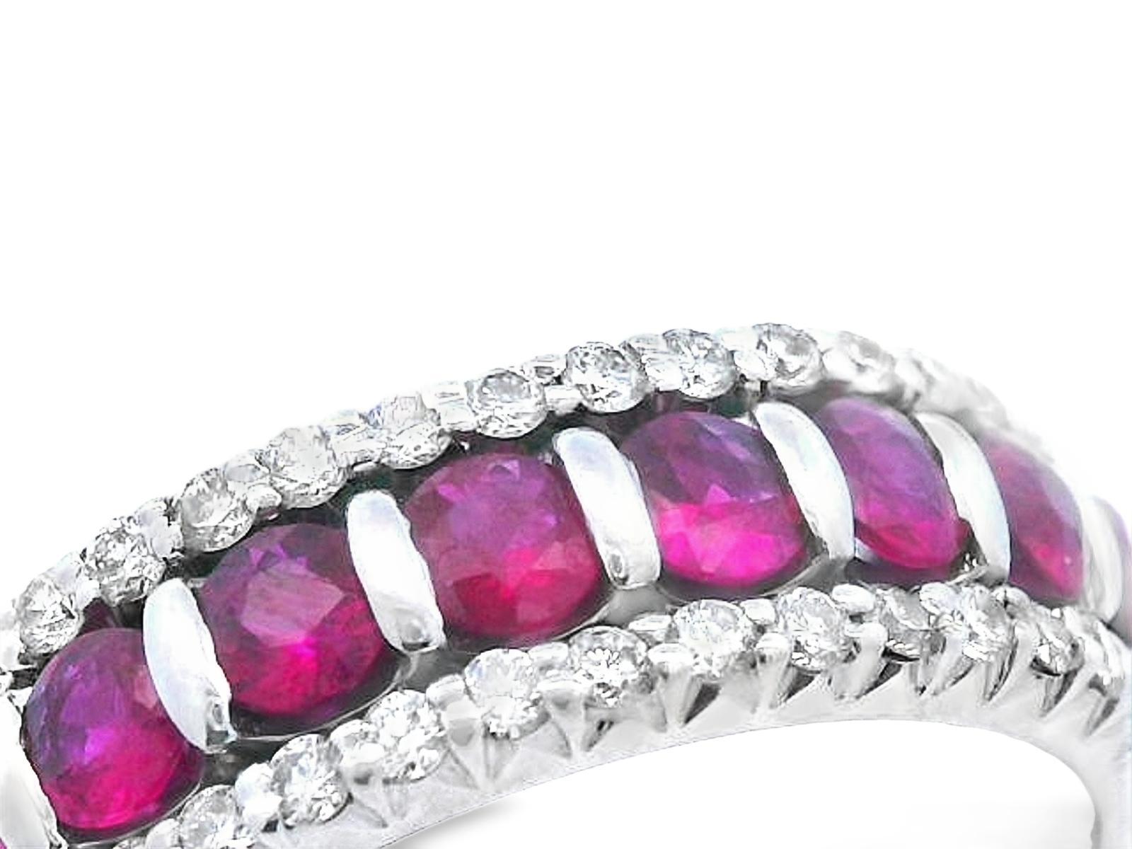 This vibrant band is made in 14k white gold with both natural rubies and diamonds. The ring is made of three 14k white gold half bands that have been joined together. Both of the outer bands contain a straight row of bright white diamonds, and the