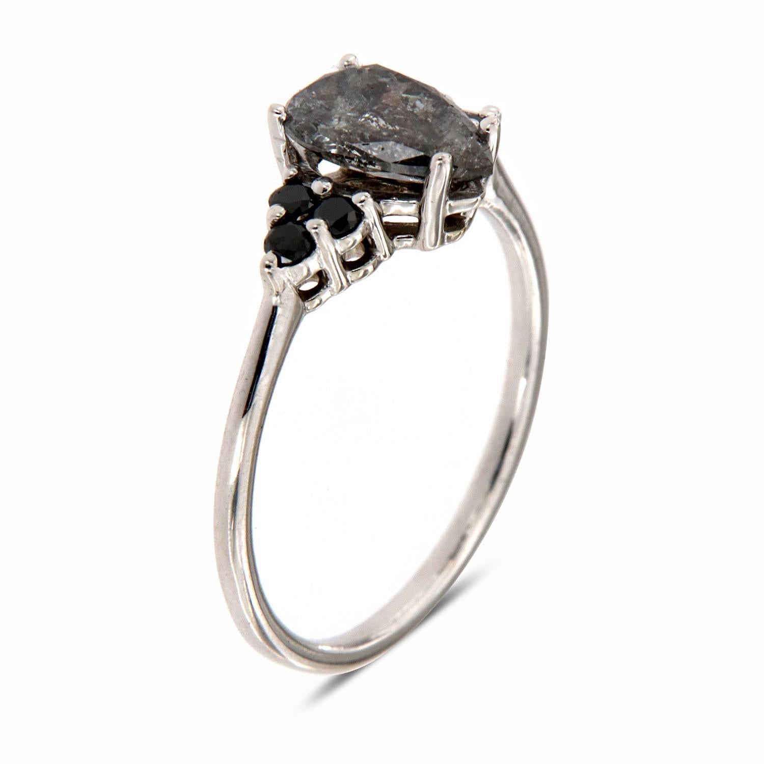 This Earthy design ring features six (6) Round-shaped Black Diamonds prong set on top of a 1.3 MM wide band. In the center is placed a 0.95 carat ( a touch less than 1 carat) Pear shape Salt and Pepper diamond. This delicate vintage ring represents