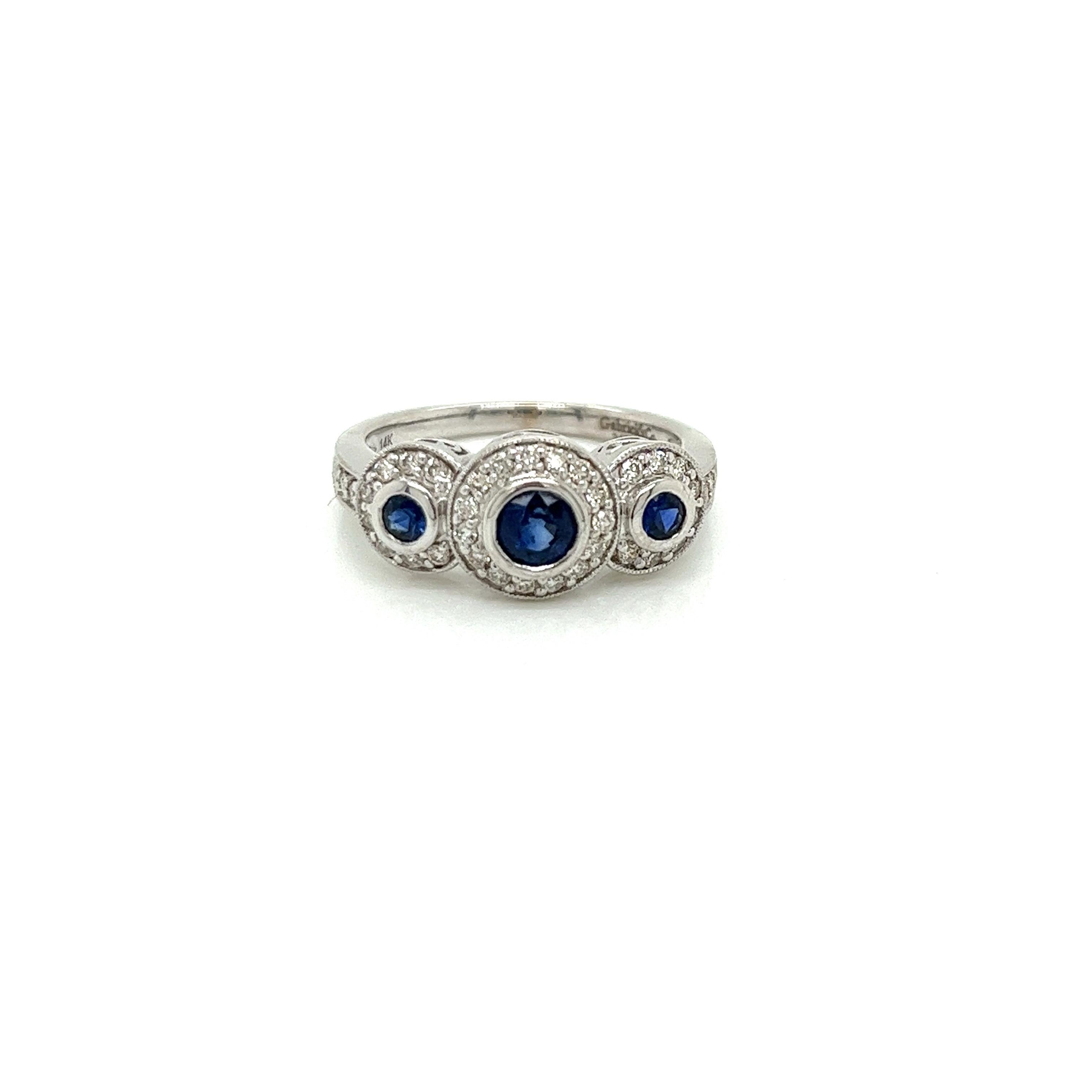 14K White Gold Sapphire and Diamond 3 stone Halo Ring. There are 3 round Ceylon Sapphires that weigh approximately .50ct with very fine blue color. A total of 35 round diamonds set in the halos and on the band weigh approximately .30ct with a