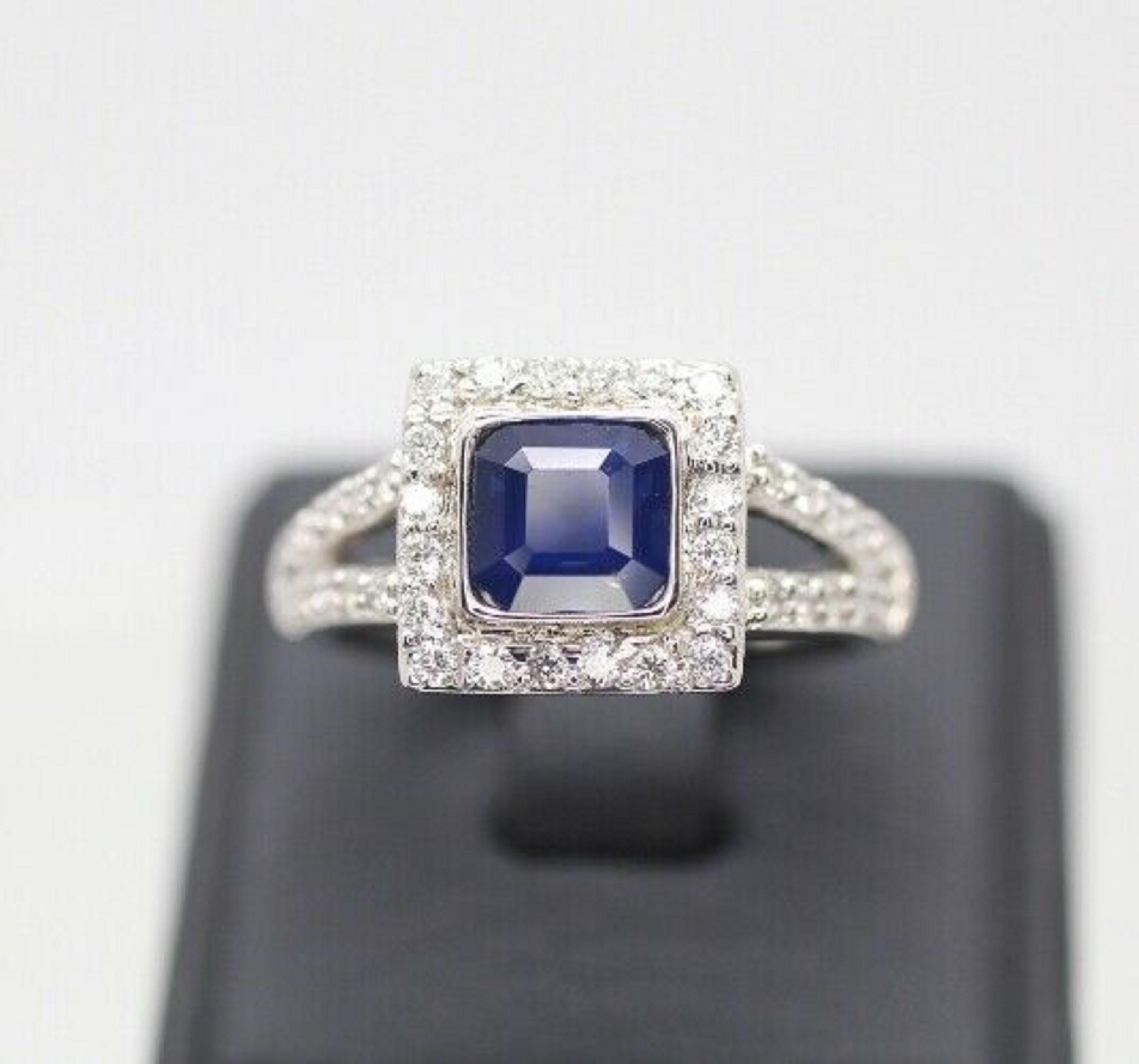   The simplicity of the ring that makes it so spectacular. It is a very nice 6.7mm asscher cut blue sapphire color. The halo consists of fully cut round diamonds that frame the sapphire perfectly. There are another 20 pieces diamonds on each side in